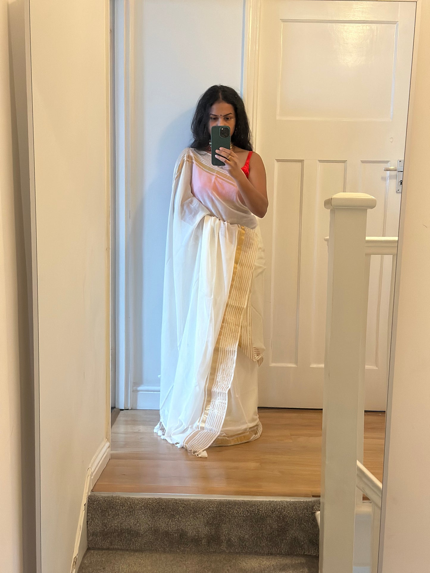 Elegant white pure mul cotton saree with gold zari border and tassels. Lightweight drape for festive and casual wear.