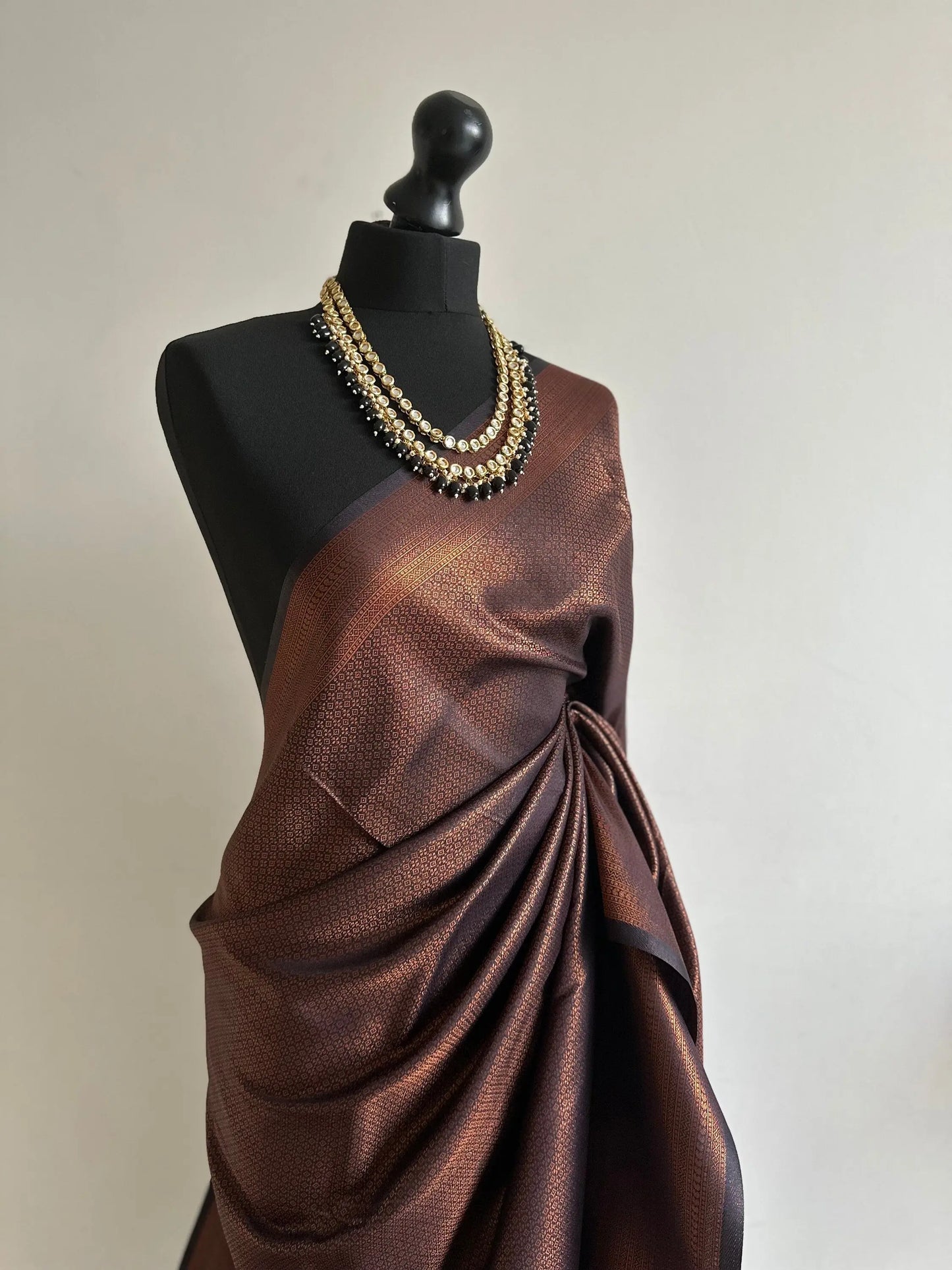 Black soft silk saree with a copper border and all over sheen. The perfect saree for parties and all traditional events. - LaiLai Sarees