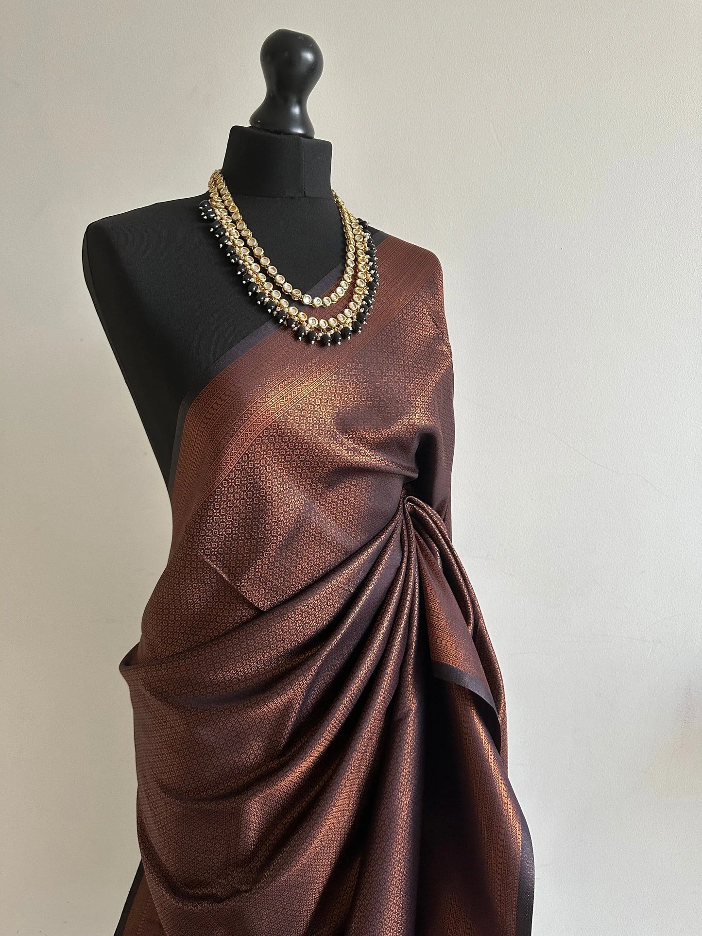 Black soft silk saree with a copper border and all over sheen. The perfect saree for parties and all traditional events. - LaiLai Sarees
