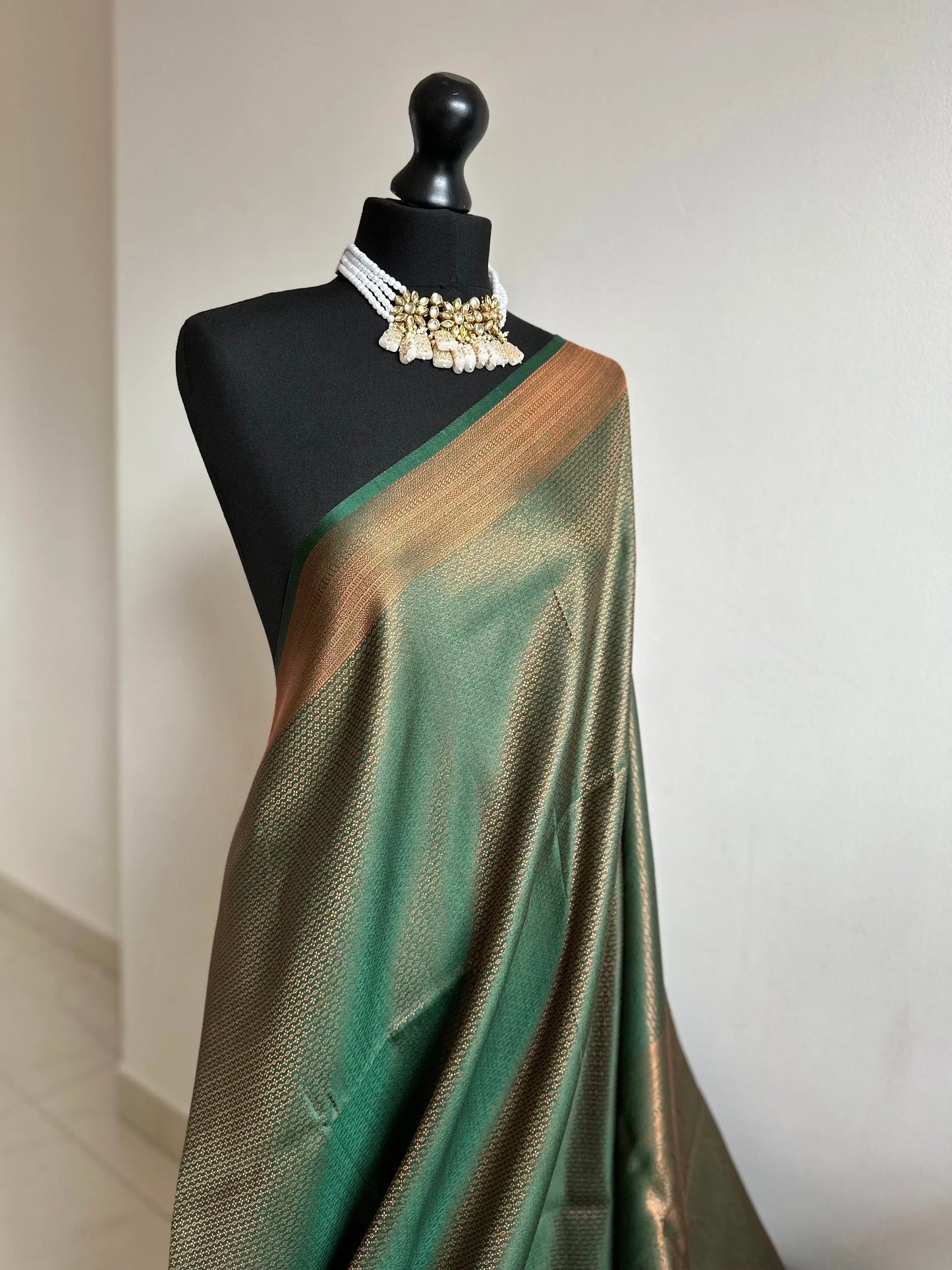 Bottle green silk saree with a copper border and all over sheen. The perfect saree for parties and all traditional events. Versatile saree - LaiLai Sarees