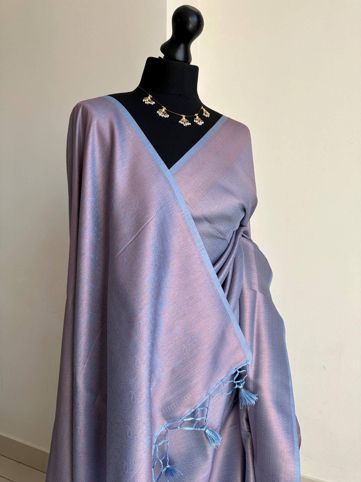 Dusty blue soft silk saree with a copper border and all over sheen. The perfect saree for parties and all traditional events.