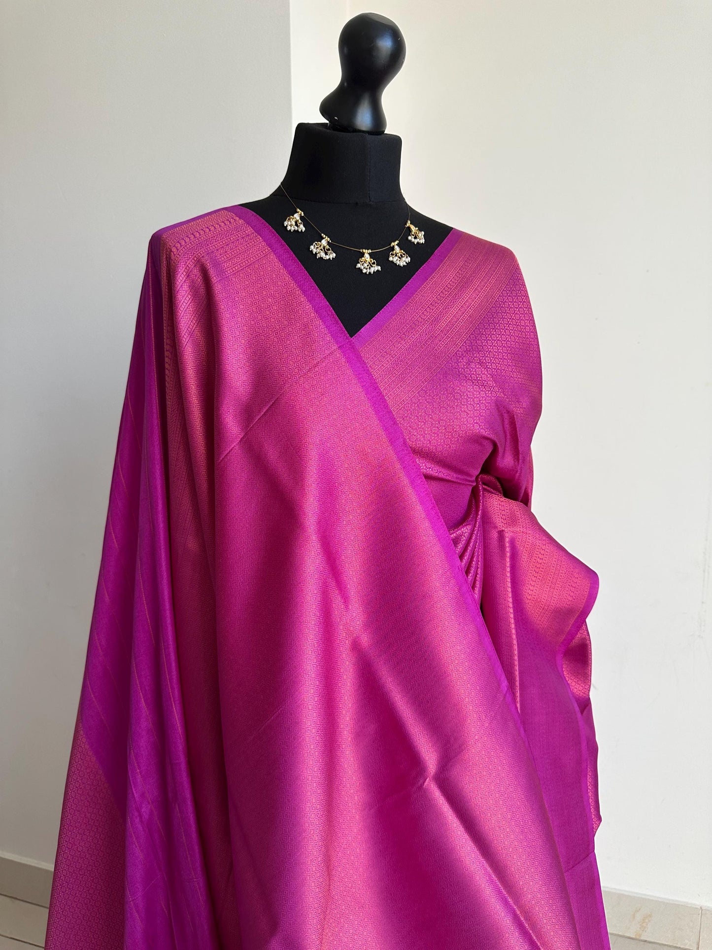 Dark pink soft silk saree with a copper border and all over sheen. This elegant rani pink saree is comes with unstitched running blouse.