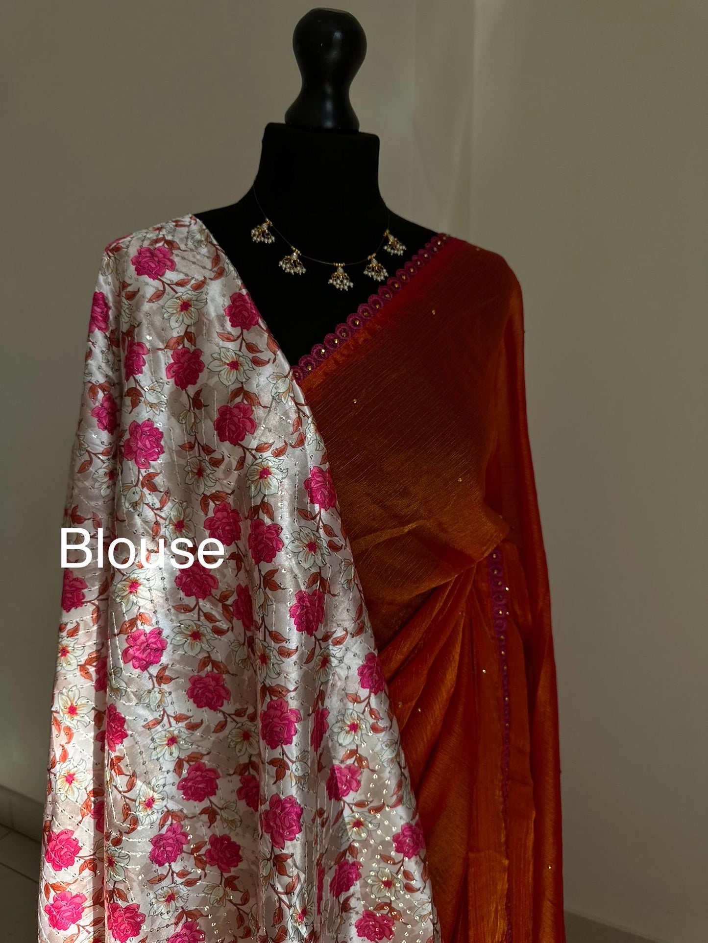 Dual toned coral party designer saree with pink trim border and contrast floral blouse. Unique statement saree can styled with other blouses