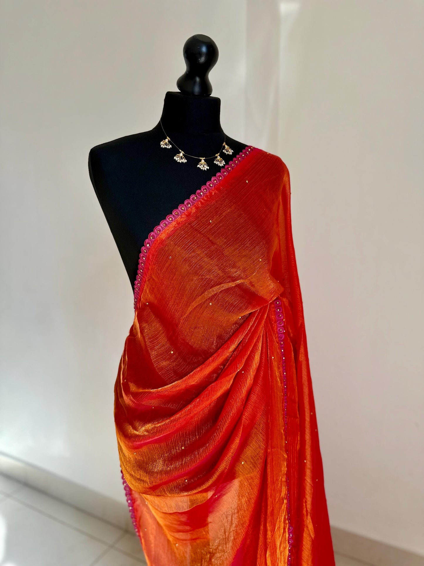Dual toned coral party designer saree with pink trim border and contrast floral blouse. Unique statement saree can styled with other blouses