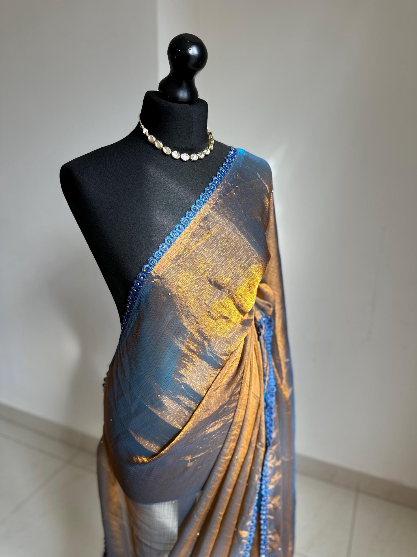 Dual toned gold party designer saree with blue trim border and contrast floral blouse. Unique statement saree can styled with other blouses