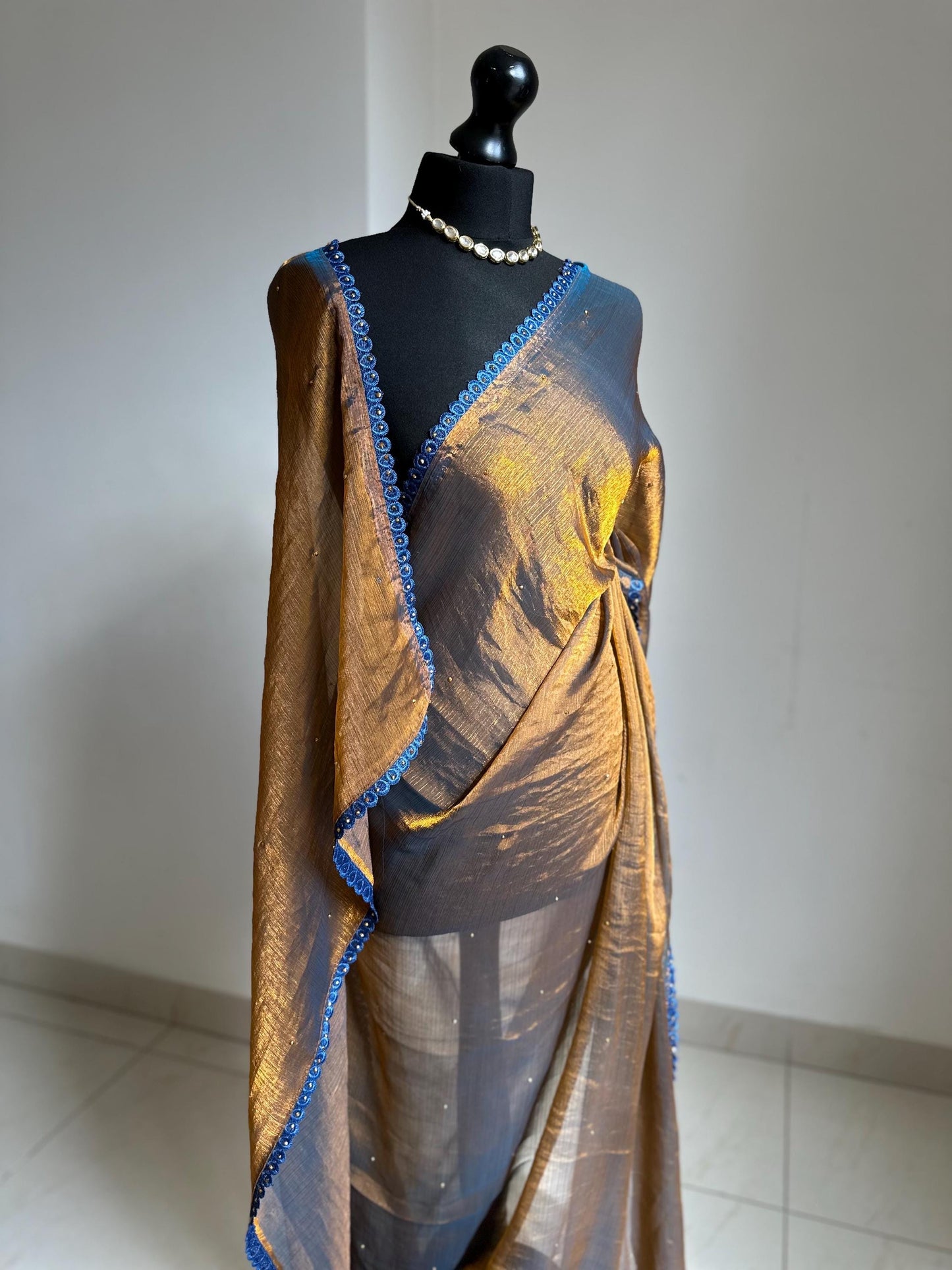 Dual toned gold party designer saree with blue trim border and contrast floral blouse. Unique statement saree can styled with other blouses