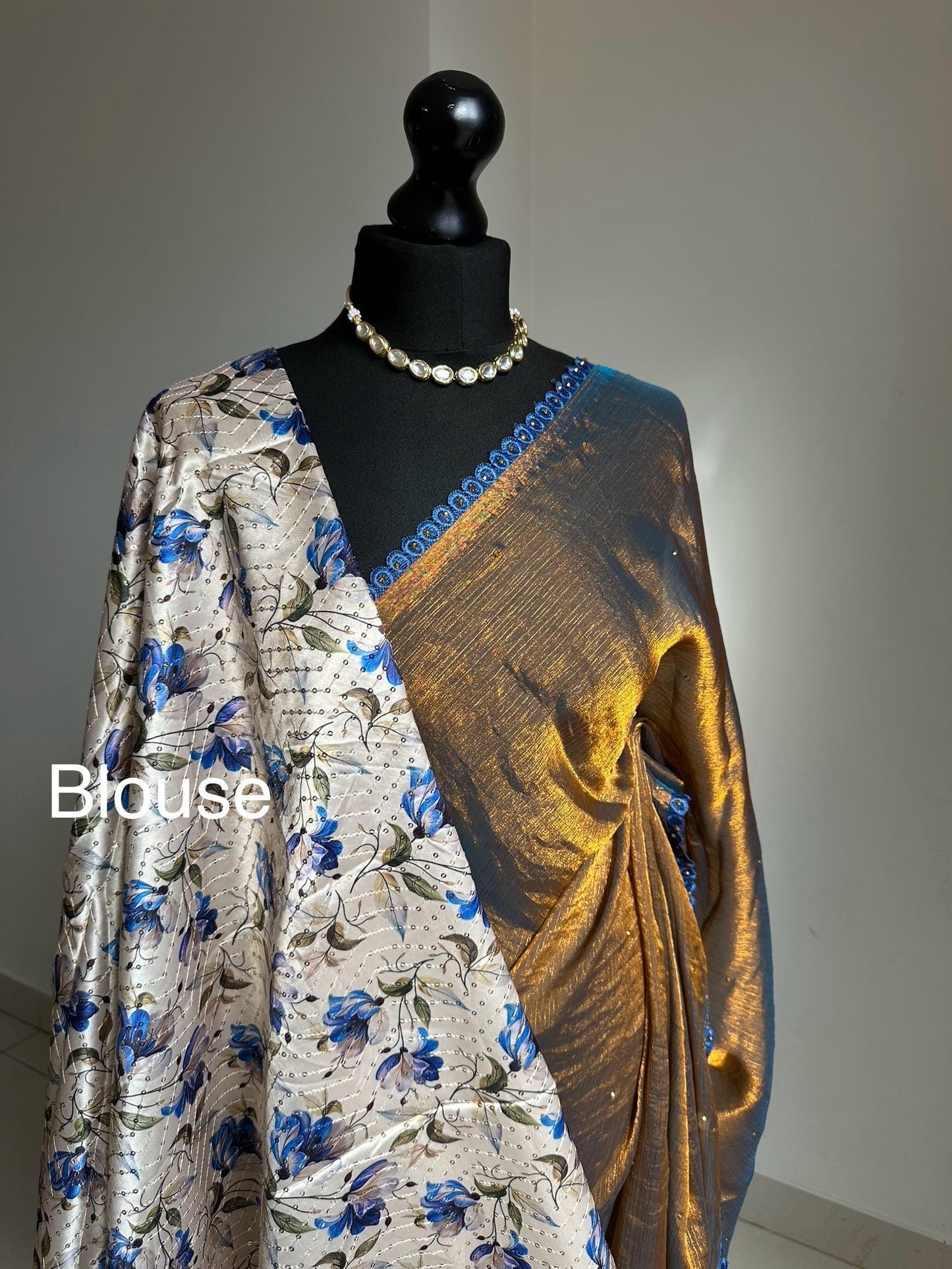 Dual toned gold party designer saree with blue trim border and contrast floral blouse. Unique statement saree can styled with other blouses