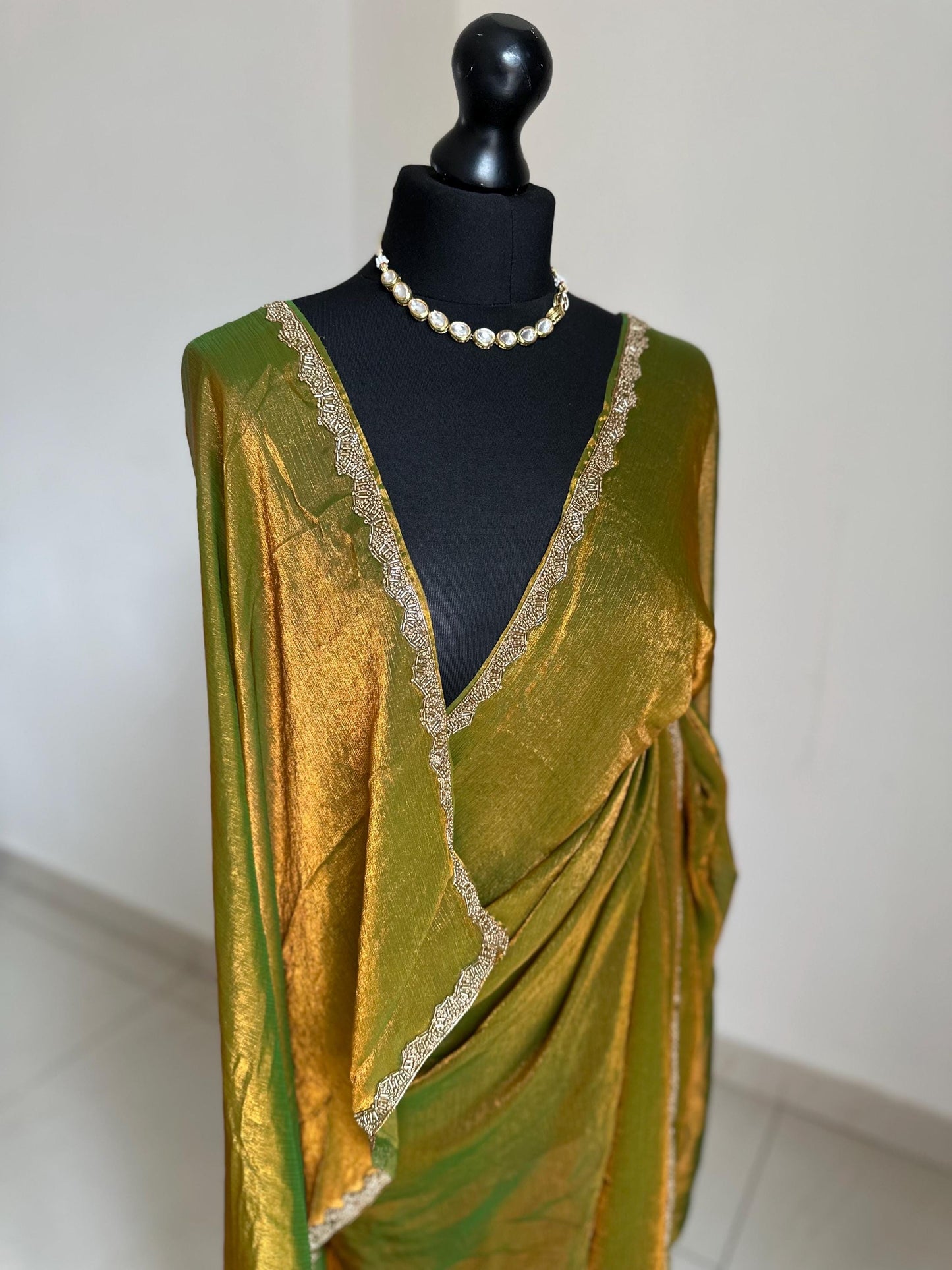Olive green chiffon saree with cutdana border. Crafted from soft shimmer chiffon this saree is perfect for parties and evening occasions