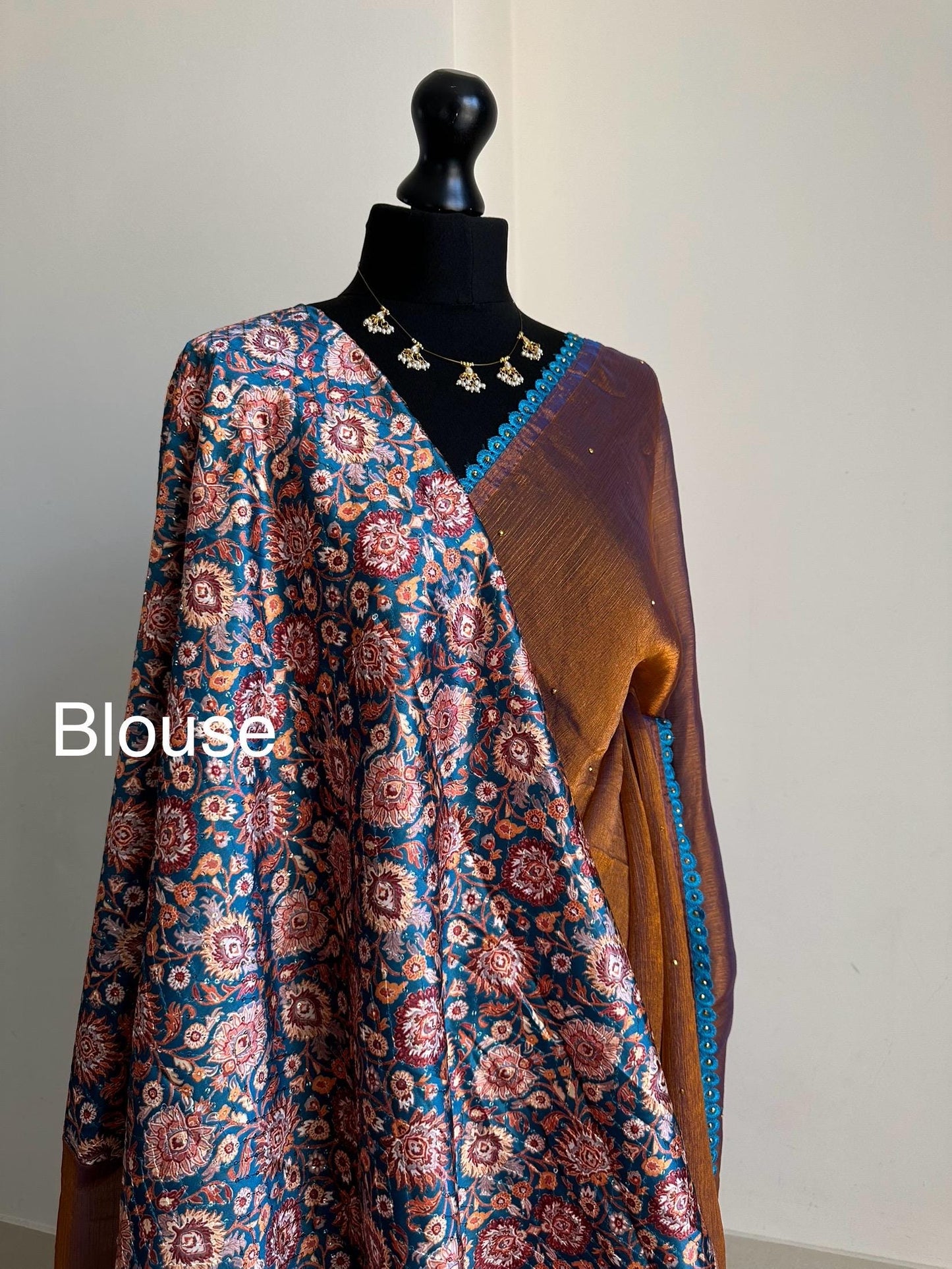 Dual toned rust party designer saree with blue trim border and contrast floral blouse. Unique statement saree can styled with other blouses