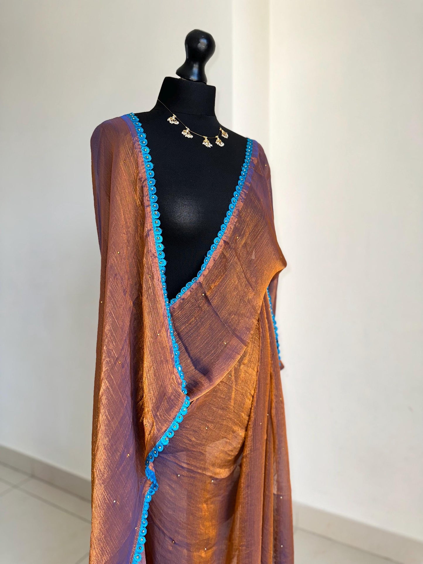 Dual toned rust party designer saree with blue trim border and contrast floral blouse. Unique statement saree can styled with other blouses