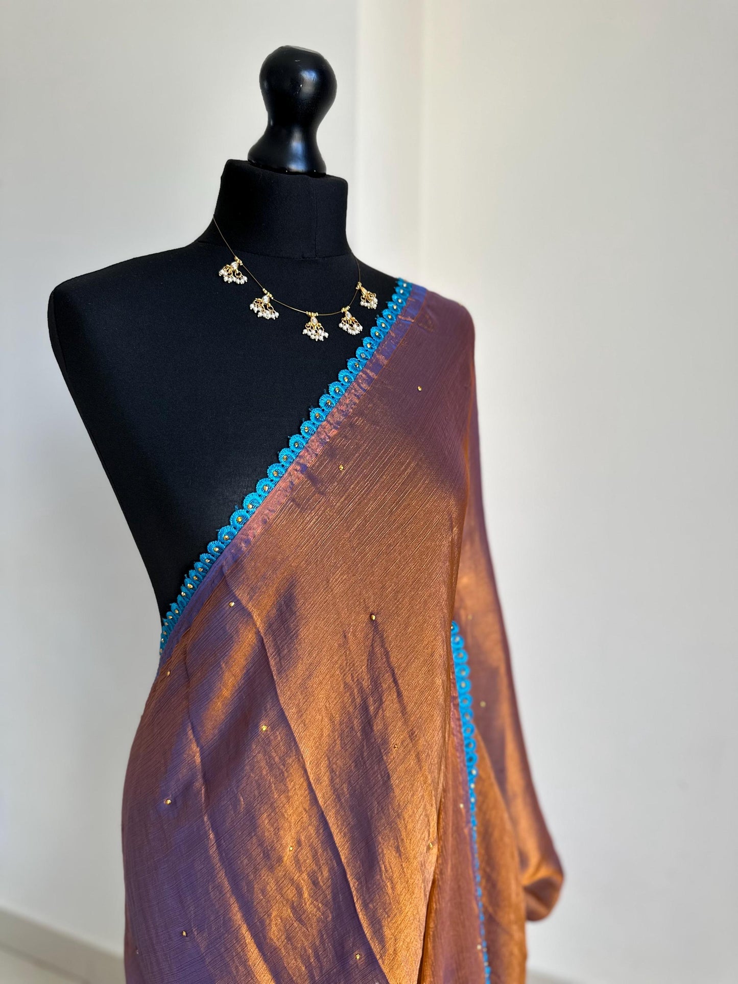 Dual toned rust party designer saree with blue trim border and contrast floral blouse. Unique statement saree can styled with other blouses