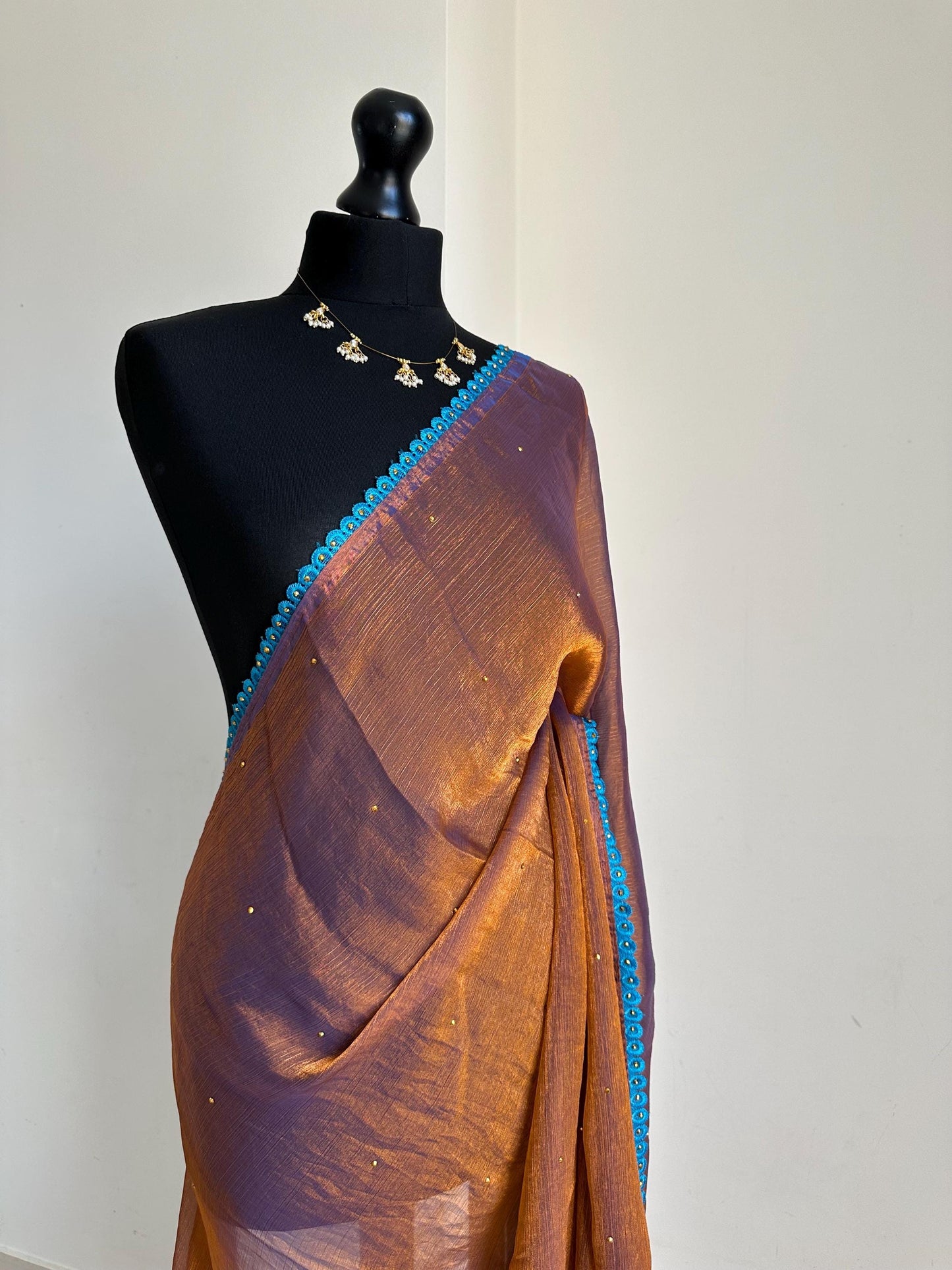 Dual toned rust party designer saree with blue trim border and contrast floral blouse. Unique statement saree can styled with other blouses