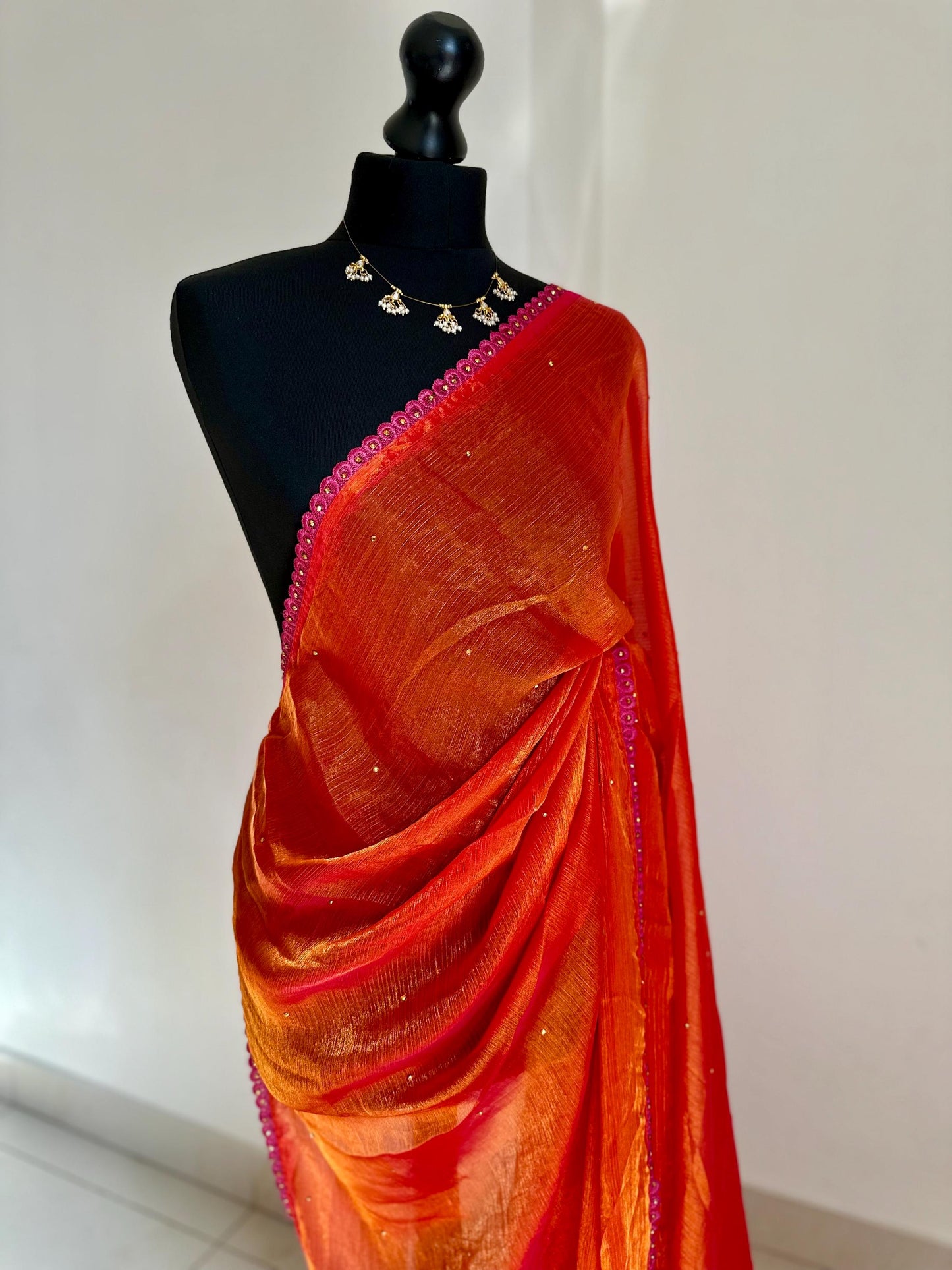 Dual toned coral party designer saree with pink trim border and contrast floral blouse. Unique statement saree can styled with other blouses