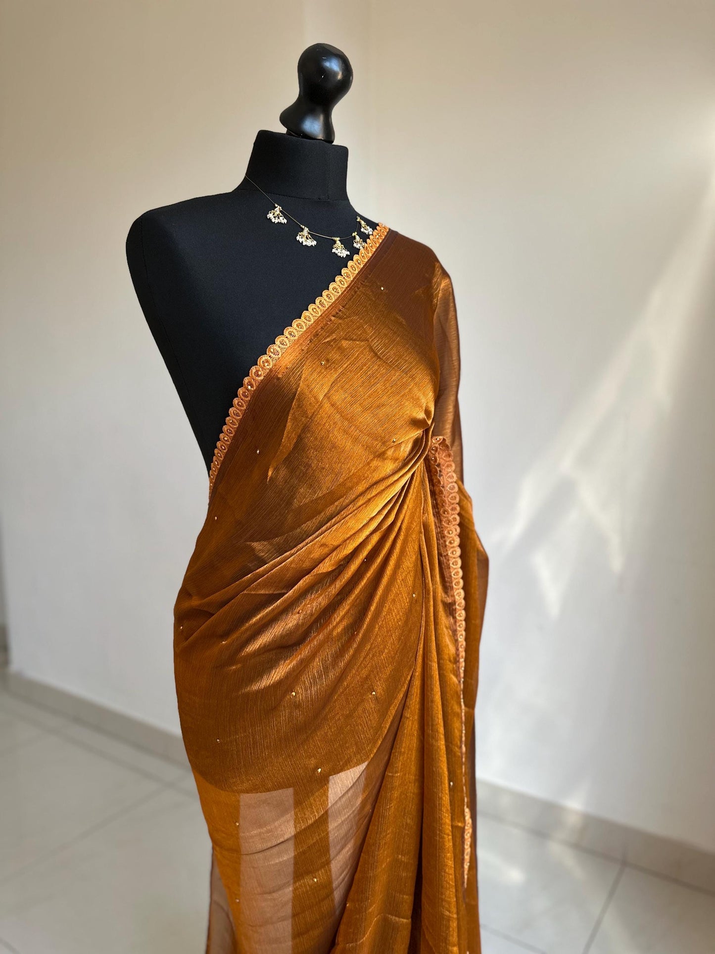 Dual toned rust party designer saree with trim border and contrast floral blouse. Unique statement saree can styled with other blouses