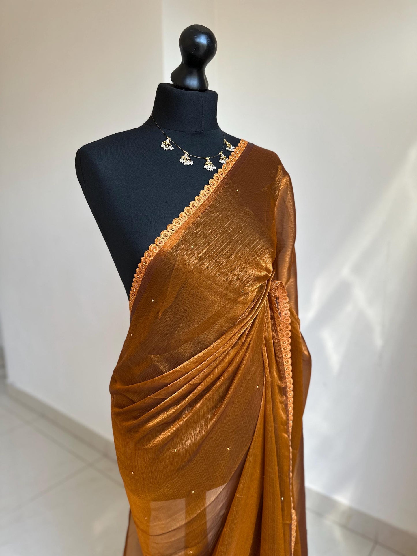 Dual toned rust party designer saree with trim border and contrast floral blouse. Unique statement saree can styled with other blouses
