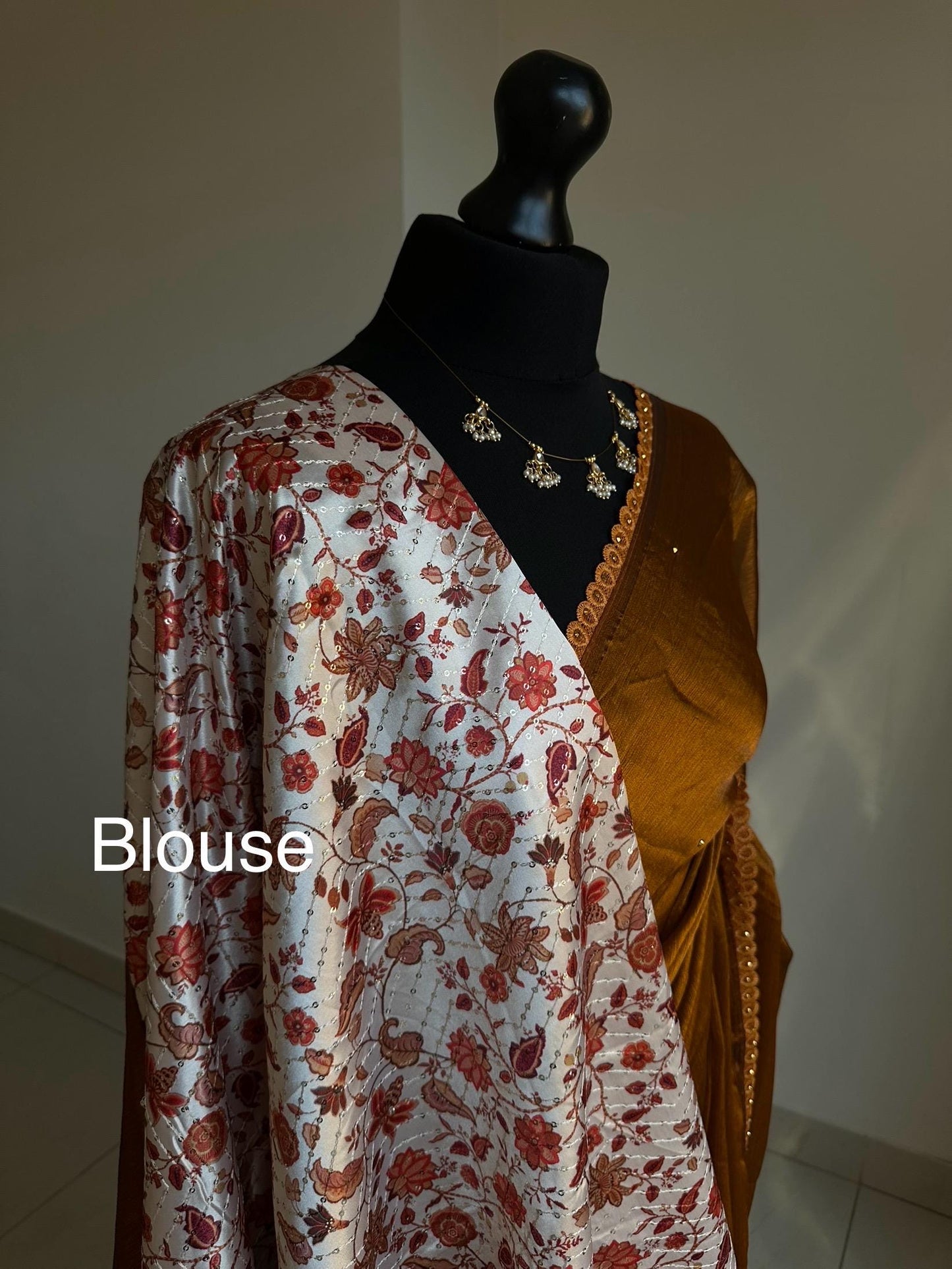 Dual toned rust party designer saree with trim border and contrast floral blouse. Unique statement saree can styled with other blouses