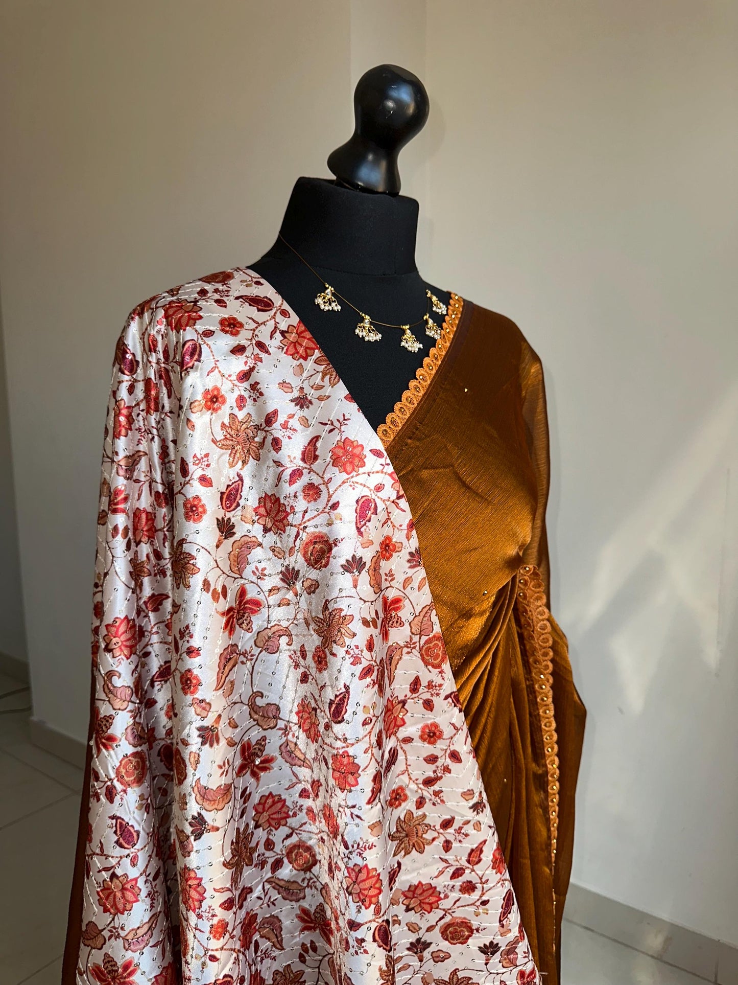 Dual toned rust party designer saree with trim border and contrast floral blouse. Unique statement saree can styled with other blouses