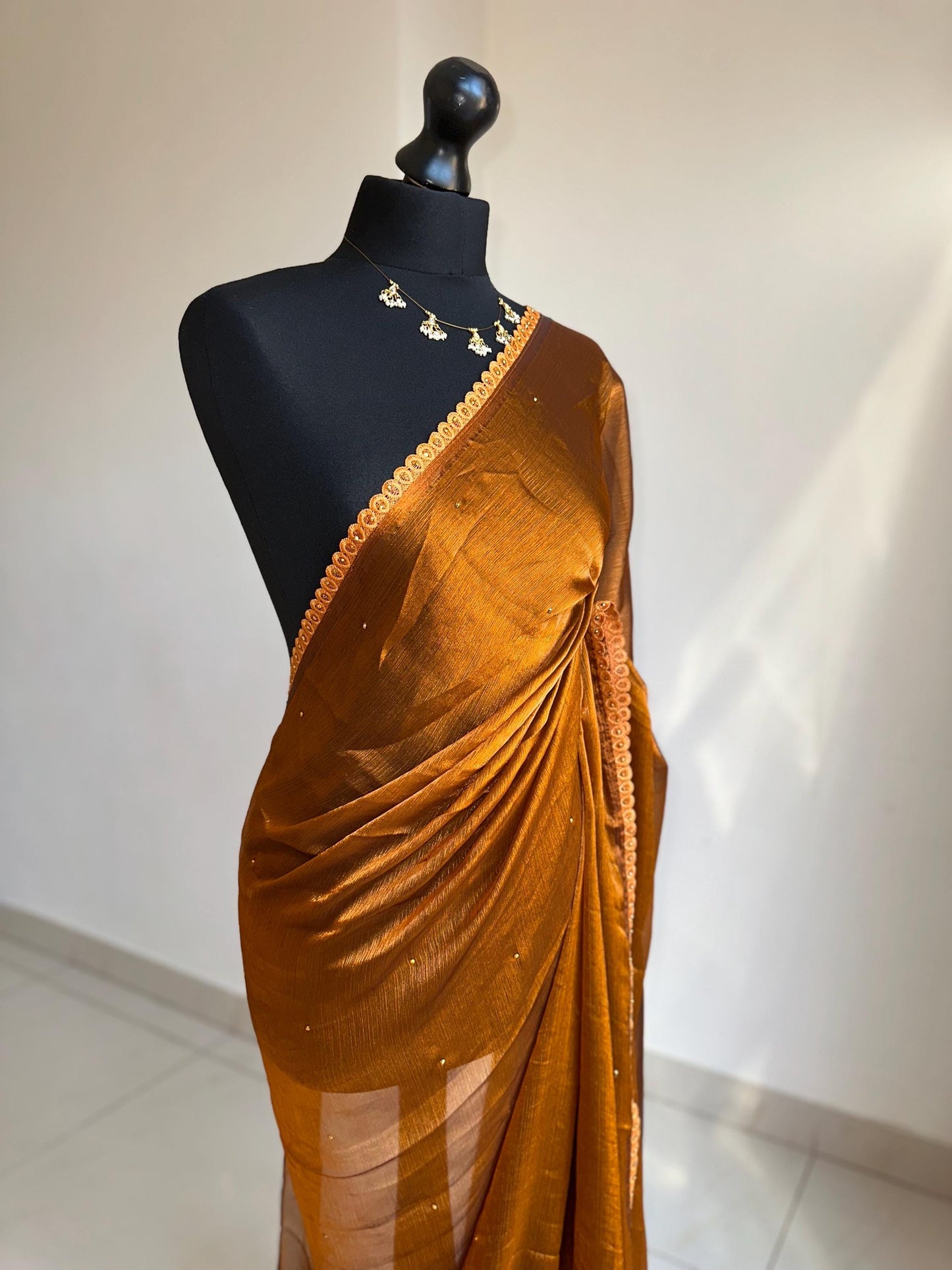 Dual toned rust party designer saree with trim border and contrast floral blouse. Unique statement saree can styled with other blouses