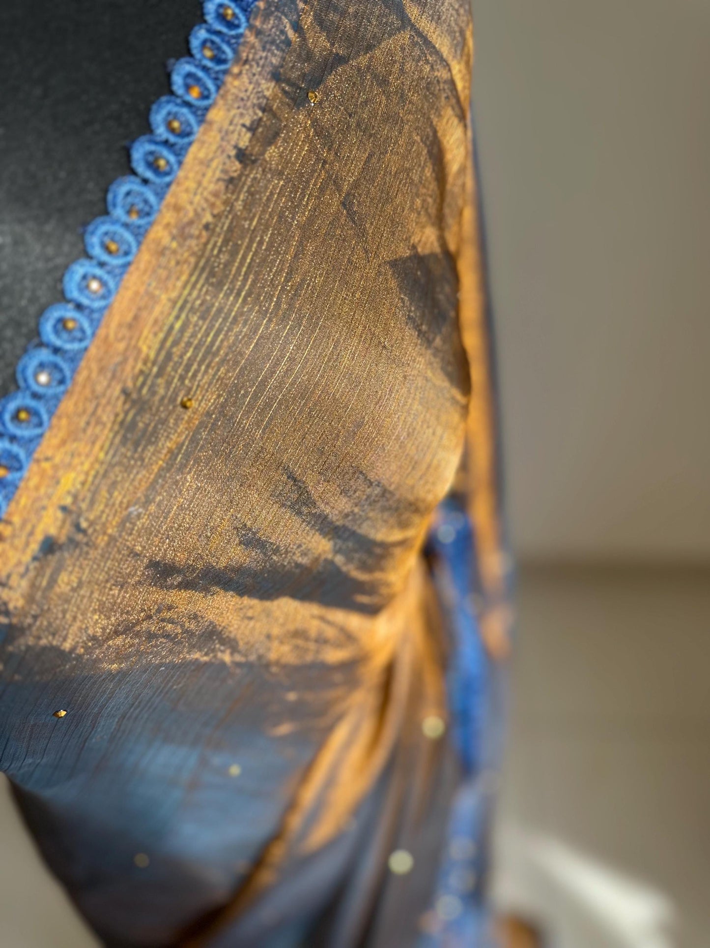 Dual toned gold party designer saree with blue trim border and contrast floral blouse. Unique statement saree can styled with other blouses