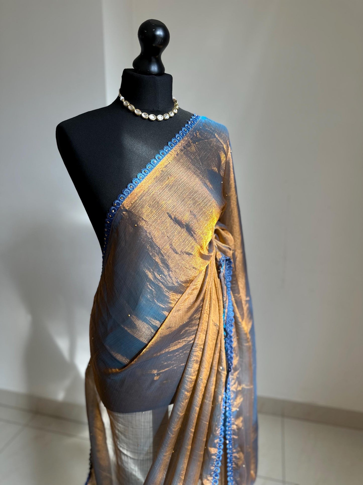 Dual toned gold party designer saree with blue trim border and contrast floral blouse. Unique statement saree can styled with other blouses