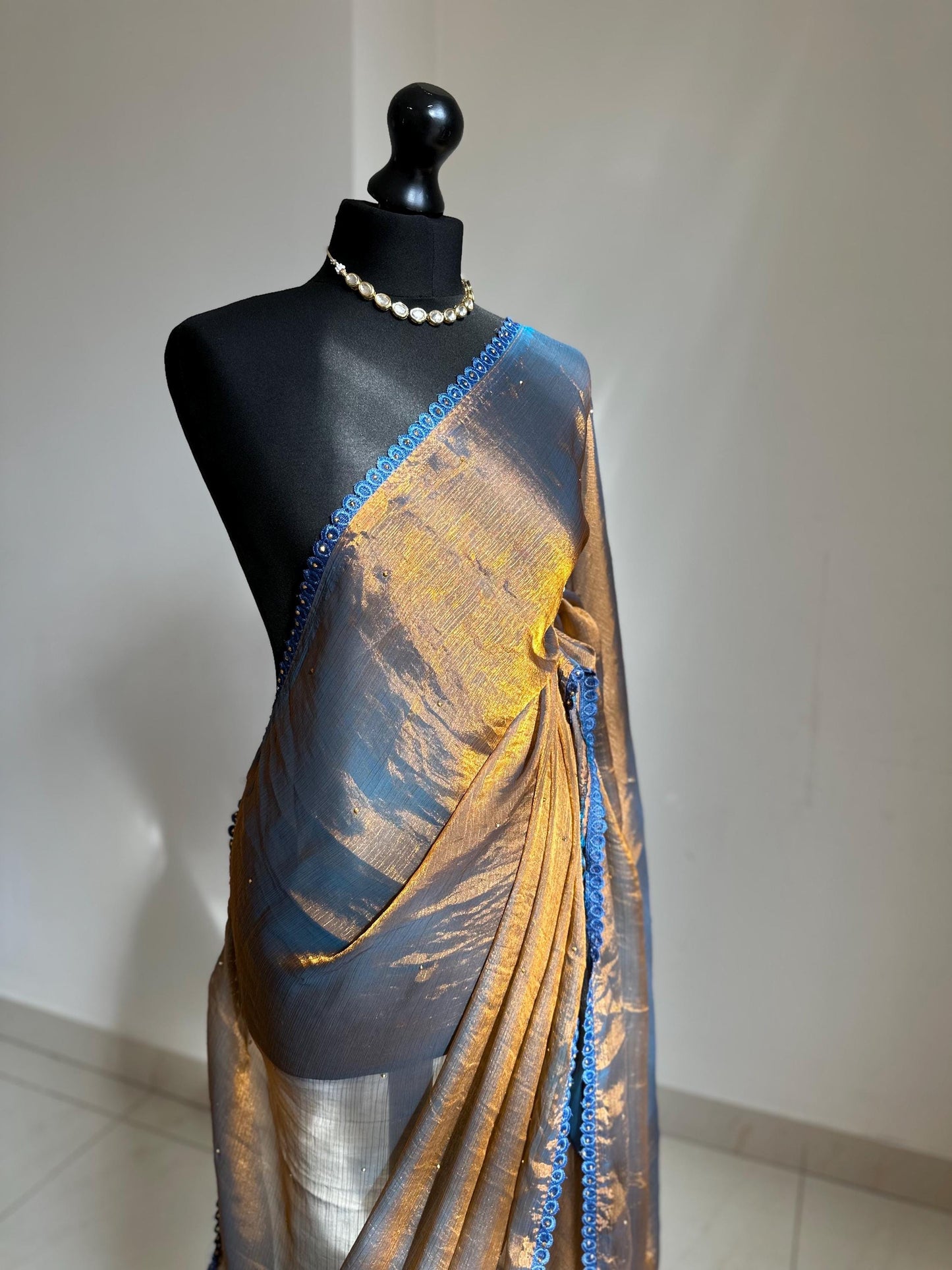 Dual toned gold party designer saree with blue trim border and contrast floral blouse. Unique statement saree can styled with other blouses