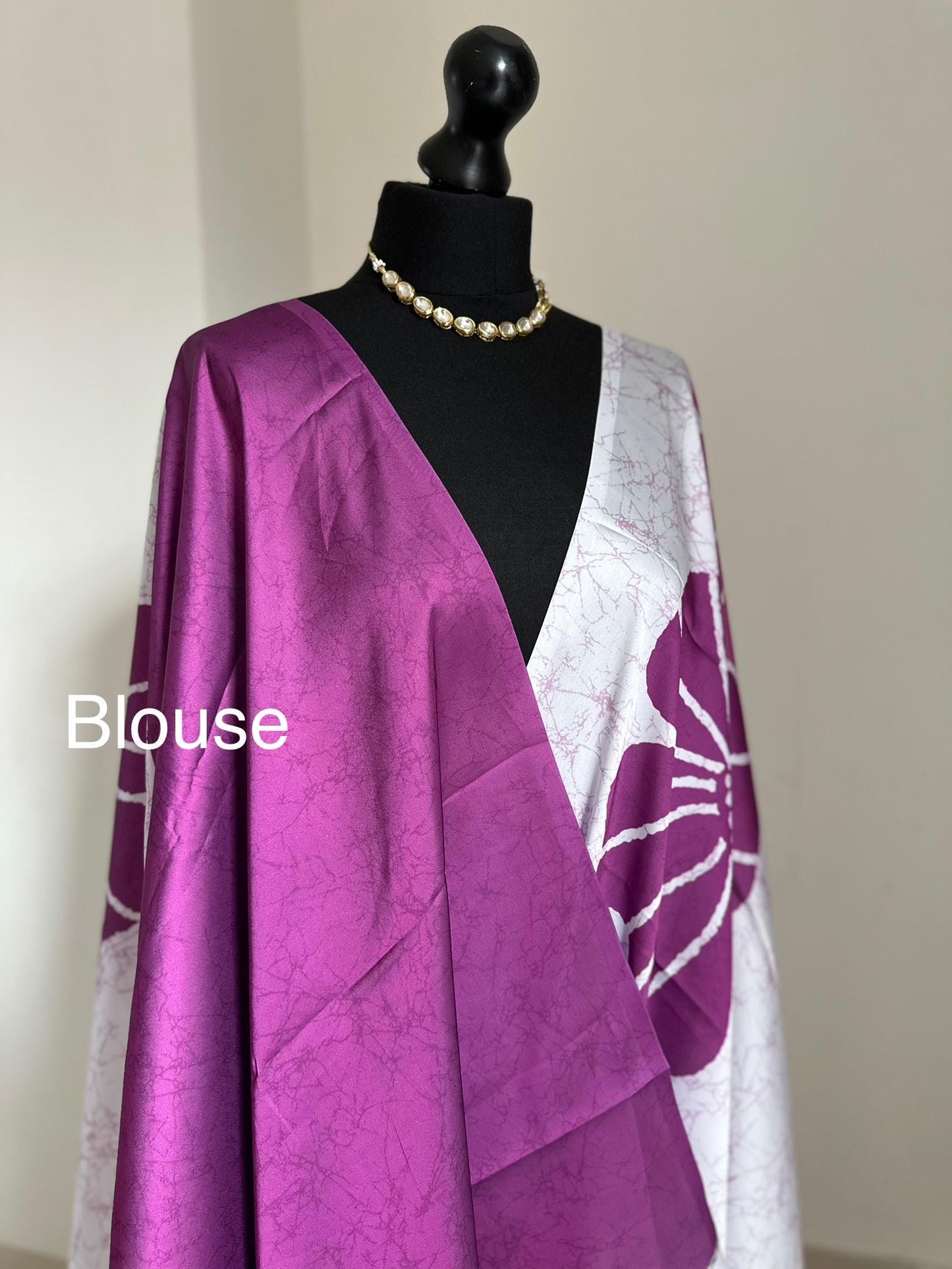 Purple floral saree with a batik-inspired design. Crafted from soft satin, this versatile piece is perfect for parties and evening occasions