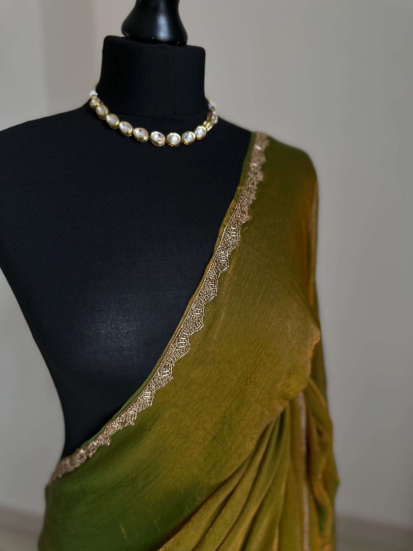 Olive green chiffon saree with cutdana border. Crafted from soft shimmer chiffon this saree is perfect for parties and evening occasions