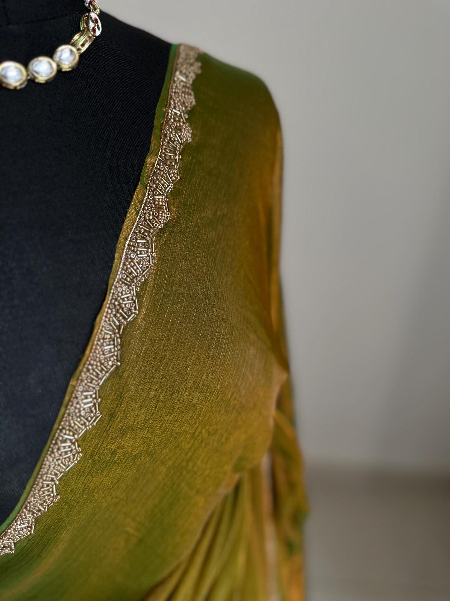 Olive green chiffon saree with cutdana border. Crafted from soft shimmer chiffon this saree is perfect for parties and evening occasions
