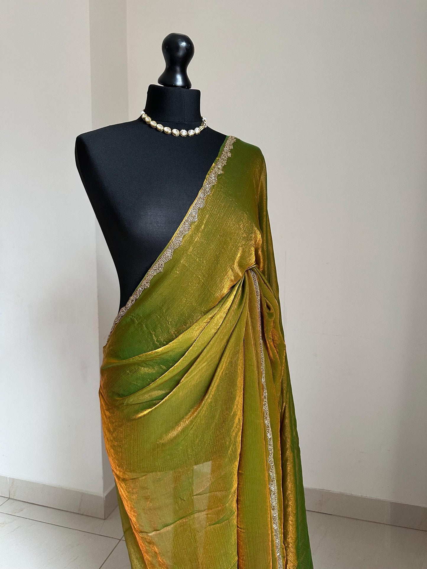 Olive green chiffon saree with cutdana border. Crafted from soft shimmer chiffon this saree is perfect for parties and evening occasions