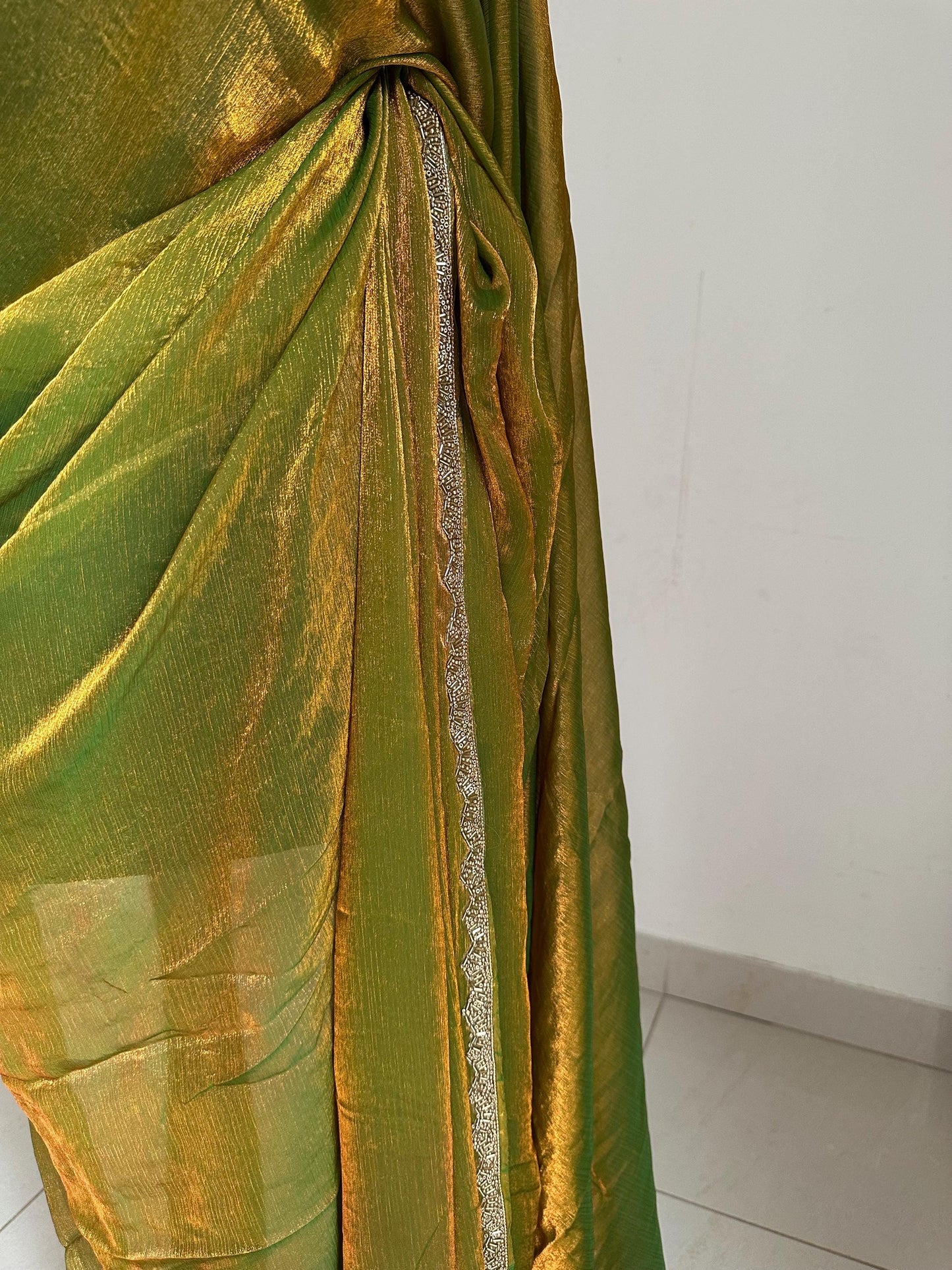 Olive green chiffon saree with cutdana border. Crafted from soft shimmer chiffon this saree is perfect for parties and evening occasions
