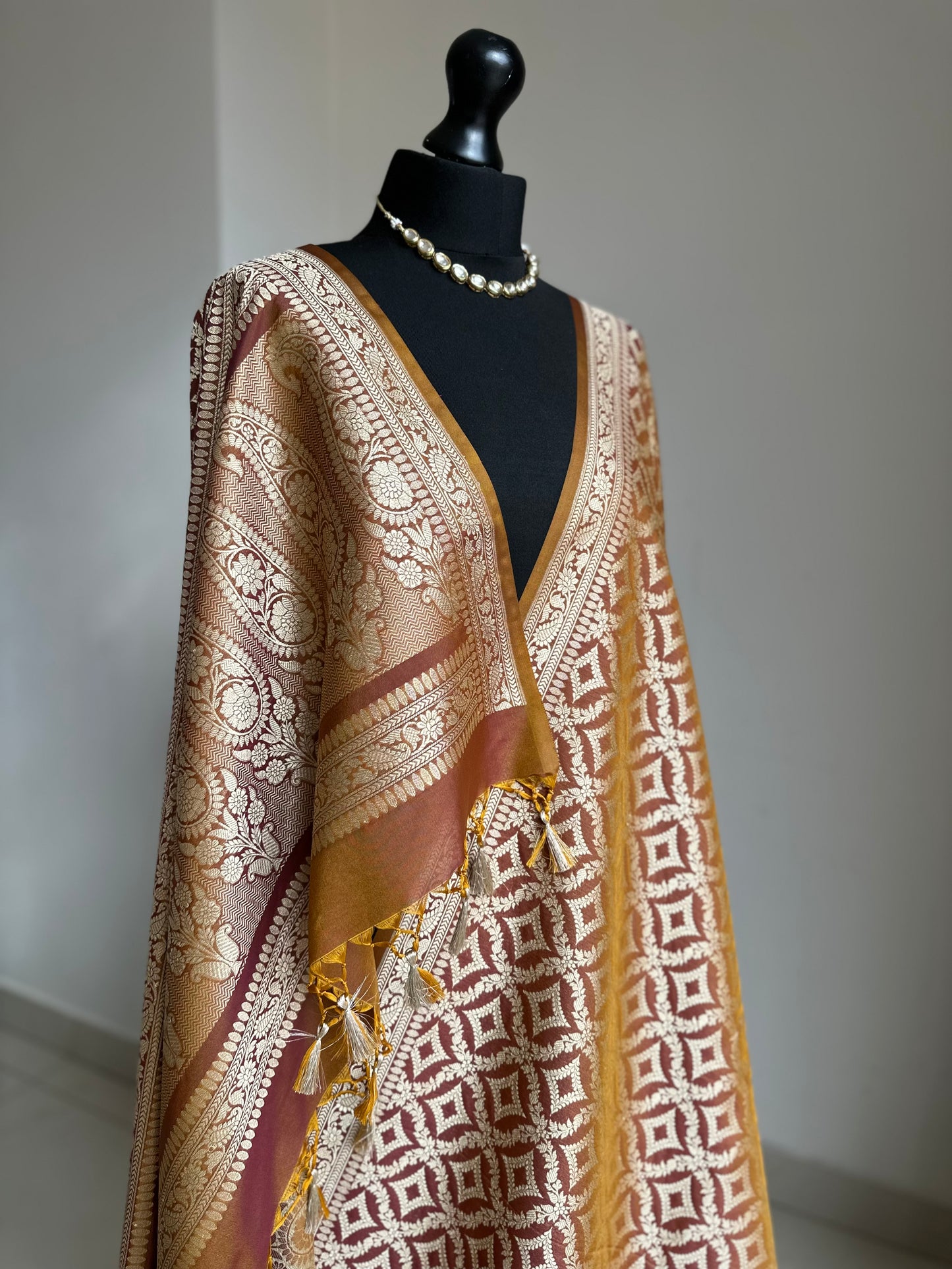 Dual-toned Banarasi silk saree in brown with golden mustard hues.