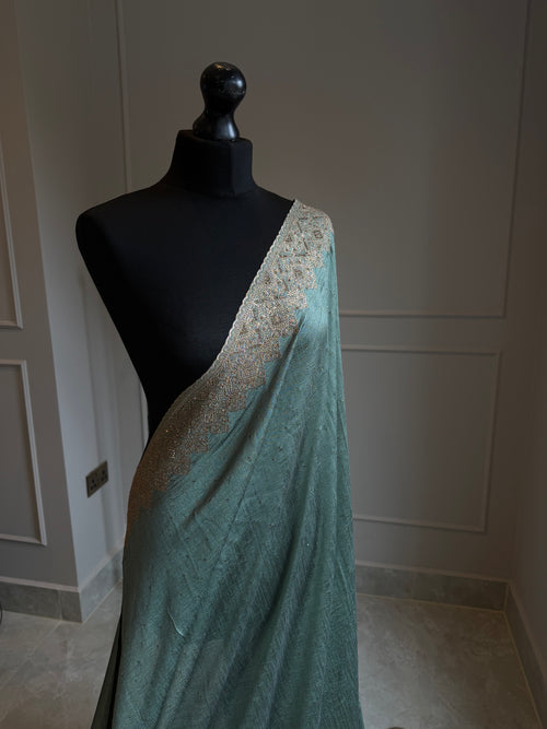 Teal georgette saree with antique gold stonework border