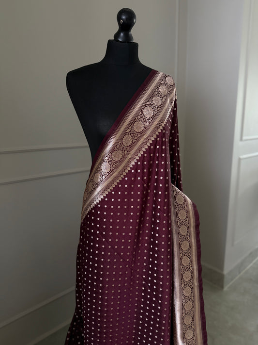 Dark maroon Banarasi wedding saree with a hint of brown. Finished with elegant gold zari work, falls, picot and tassels.