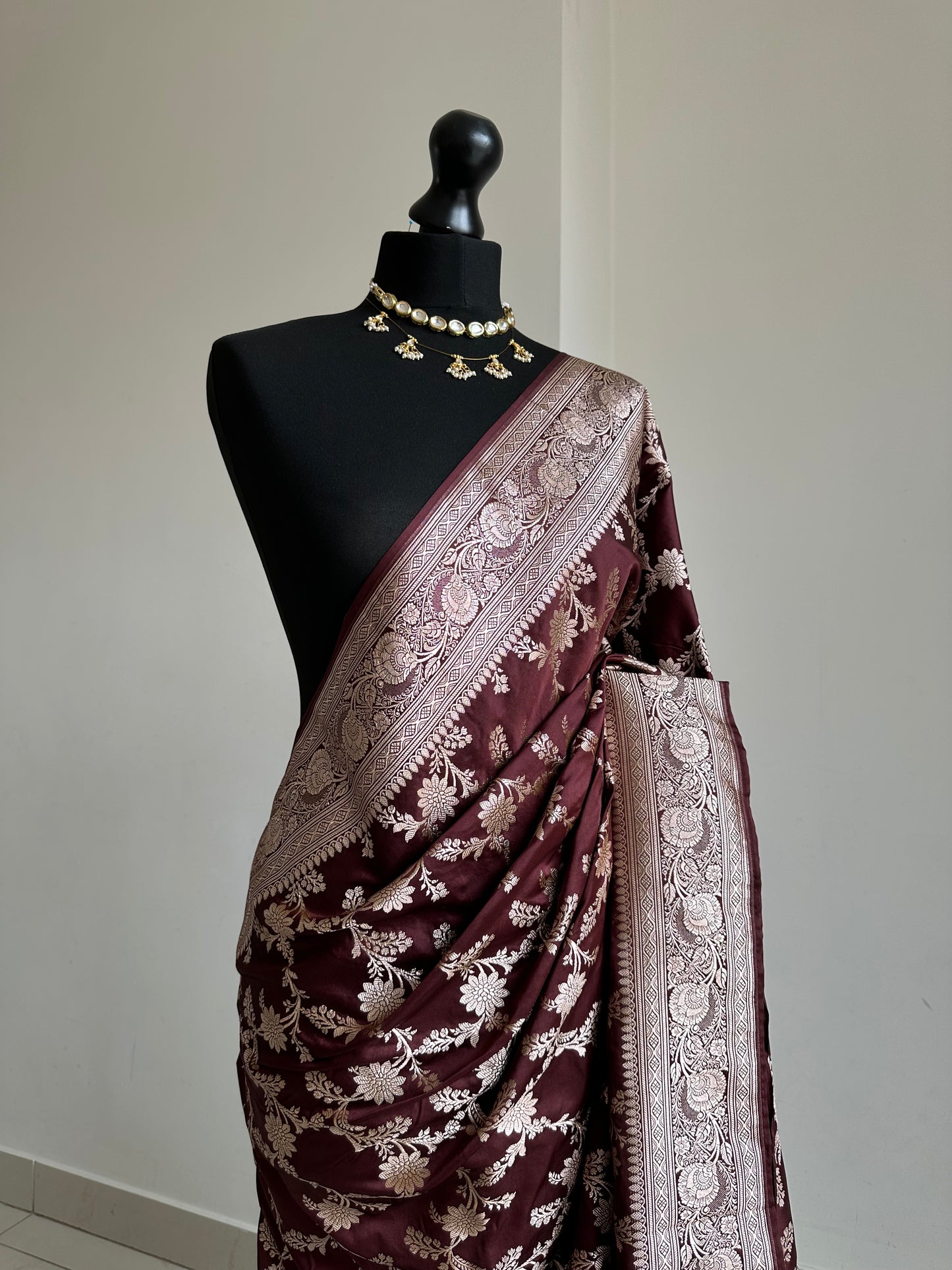 Banarasi silk in dark chocolate brown with maroon hues gold zari. Gold and brown traditional wedding saree with jaal design and and plain contrast blouse with cuff border