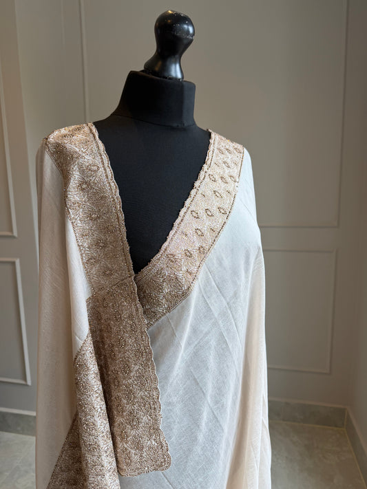 Off-white fluid drape saree with zardosi work border and pallu in antique gold