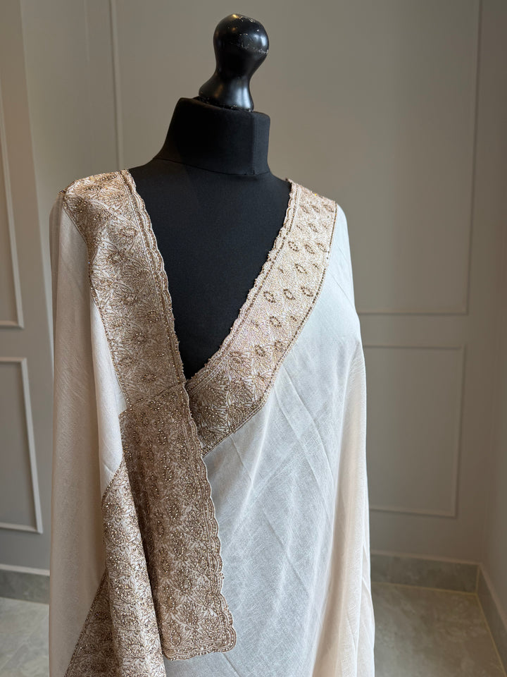 Off-white fluid drape saree with zardosi work border and pallu in antique gold