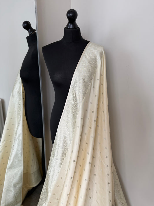 Banarasi silk cream wedding saree with champagne gold zari. Cream designer and traditional saree with plain contrast blouse.
