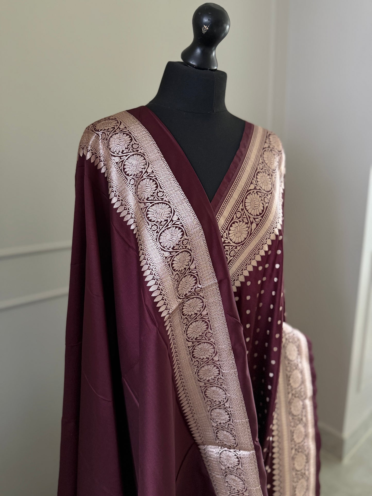 Dark maroon Banarasi wedding saree with a hint of brown. Finished with elegant gold zari work, falls, picot and tassels.
