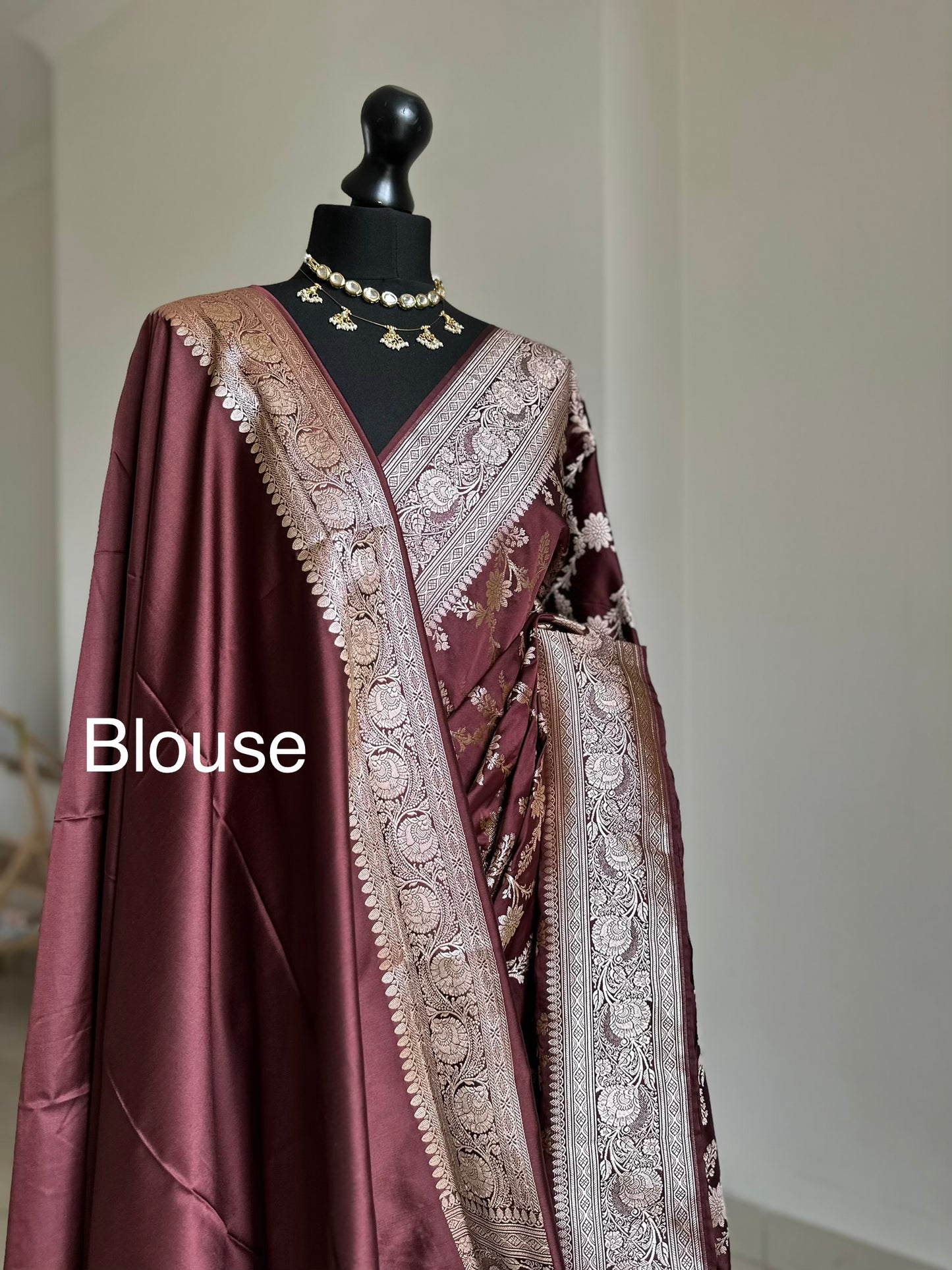 Banarasi silk in dark chocolate brown with maroon hues gold zari. Gold and brown traditional wedding saree with jaal design and and plain contrast blouse with cuff border