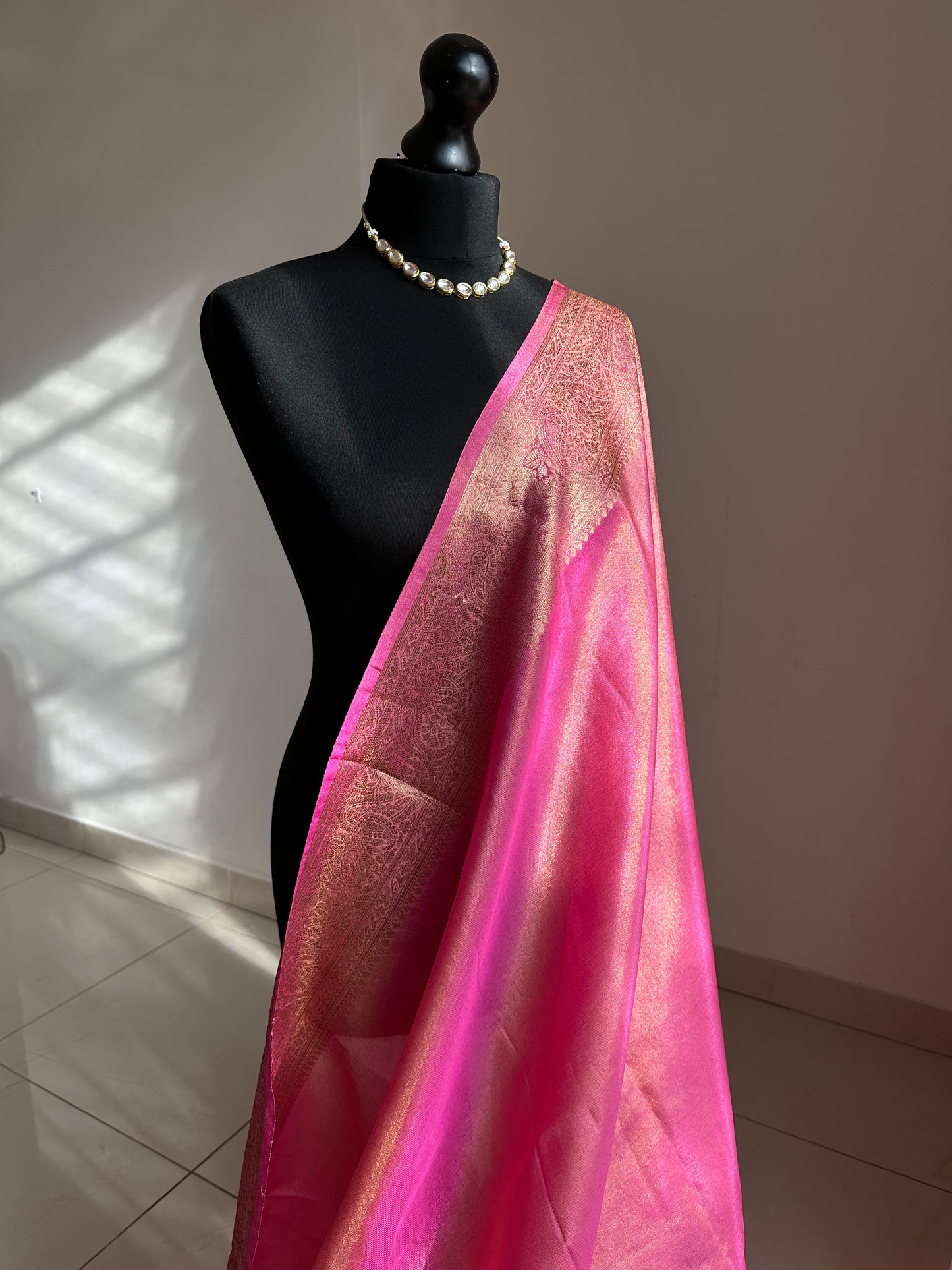 Pink and antique gold semi tissue silk saree. Unstitched brocade blouse.