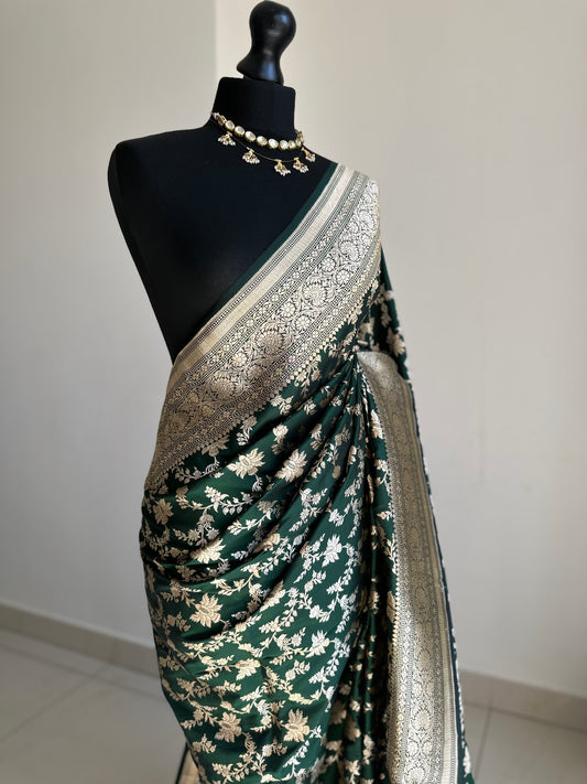 Elegant dark green pure silk Banarasi saree with intricate gold zari work and floral motifs, perfect for weddings and festive occasions