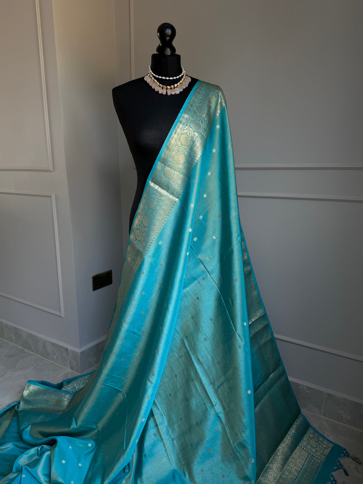 Turquoise blue firozi tissue silk saree with gold border and undertones.