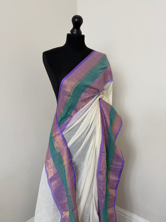 Elegant white pure mul cotton saree with purple and sea green border with gold zari weaving throughout.