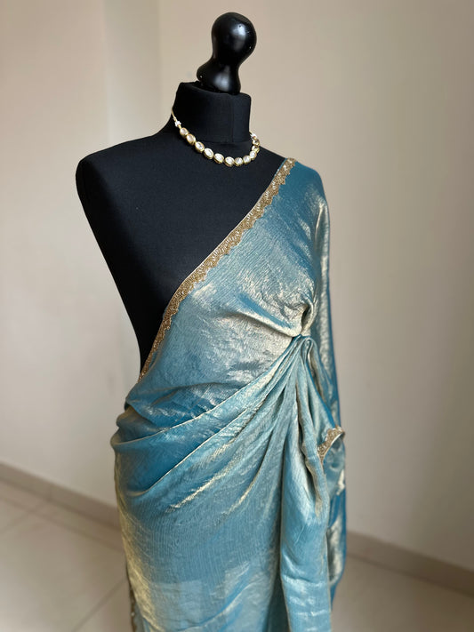 Teal blue chiffon saree with cutdana border. Crafted from soft shimmer chiffon this saree is perfect for parties and evening occasions