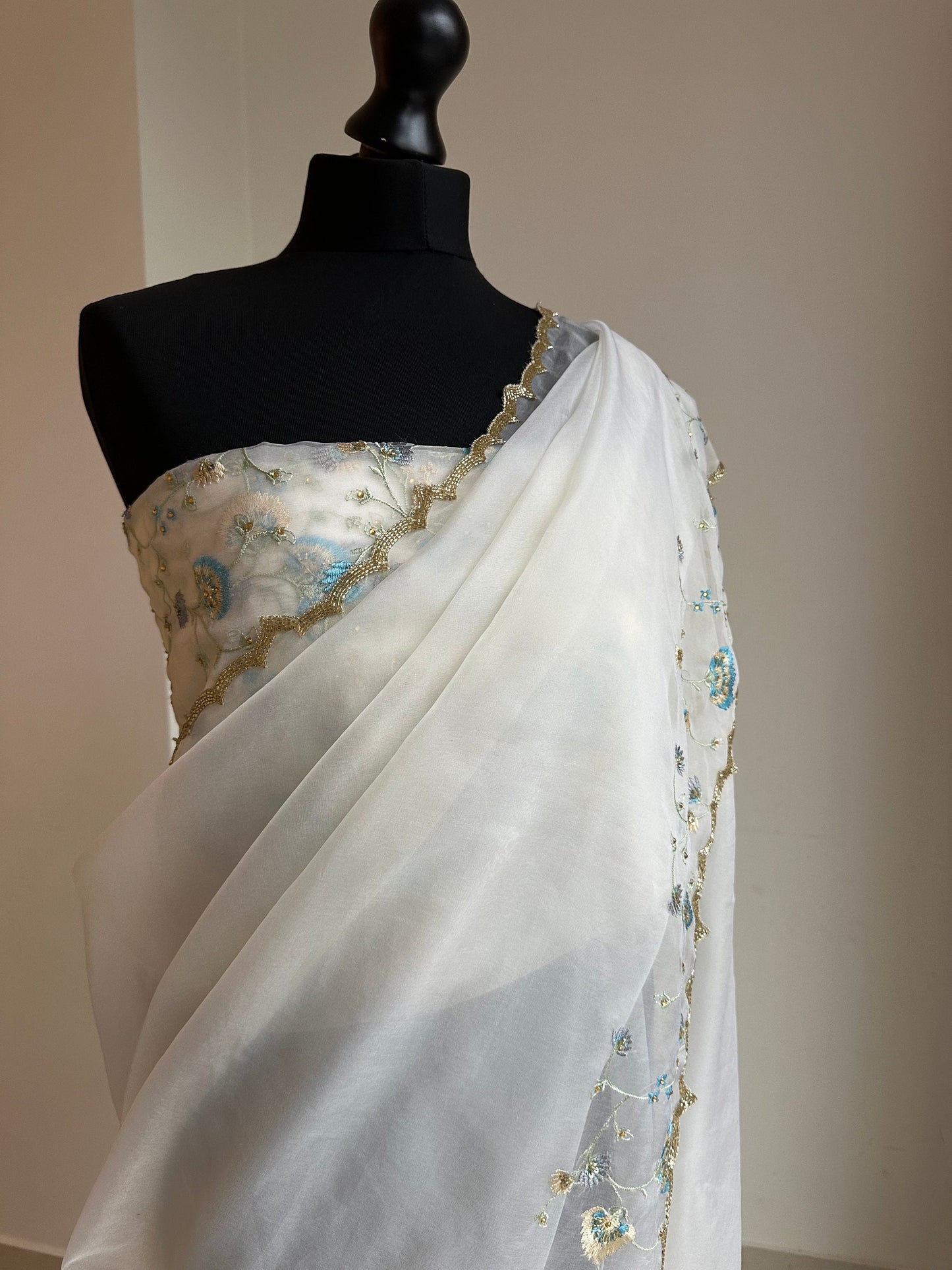 Dainty off white soft organza saree with stone work and pretty floral embroidery in shades of blue