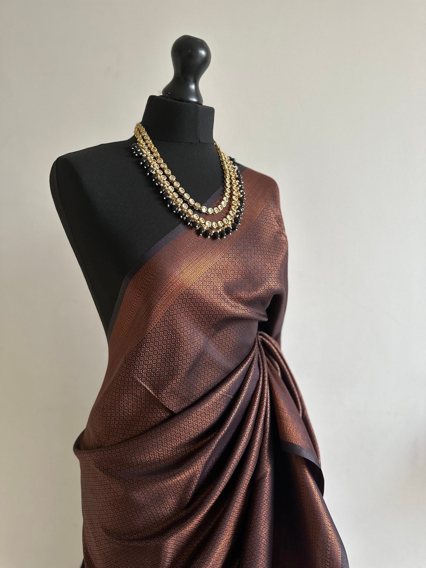 Black soft silk saree with a copper border and all over sheen. The perfect saree for parties and all traditional events.