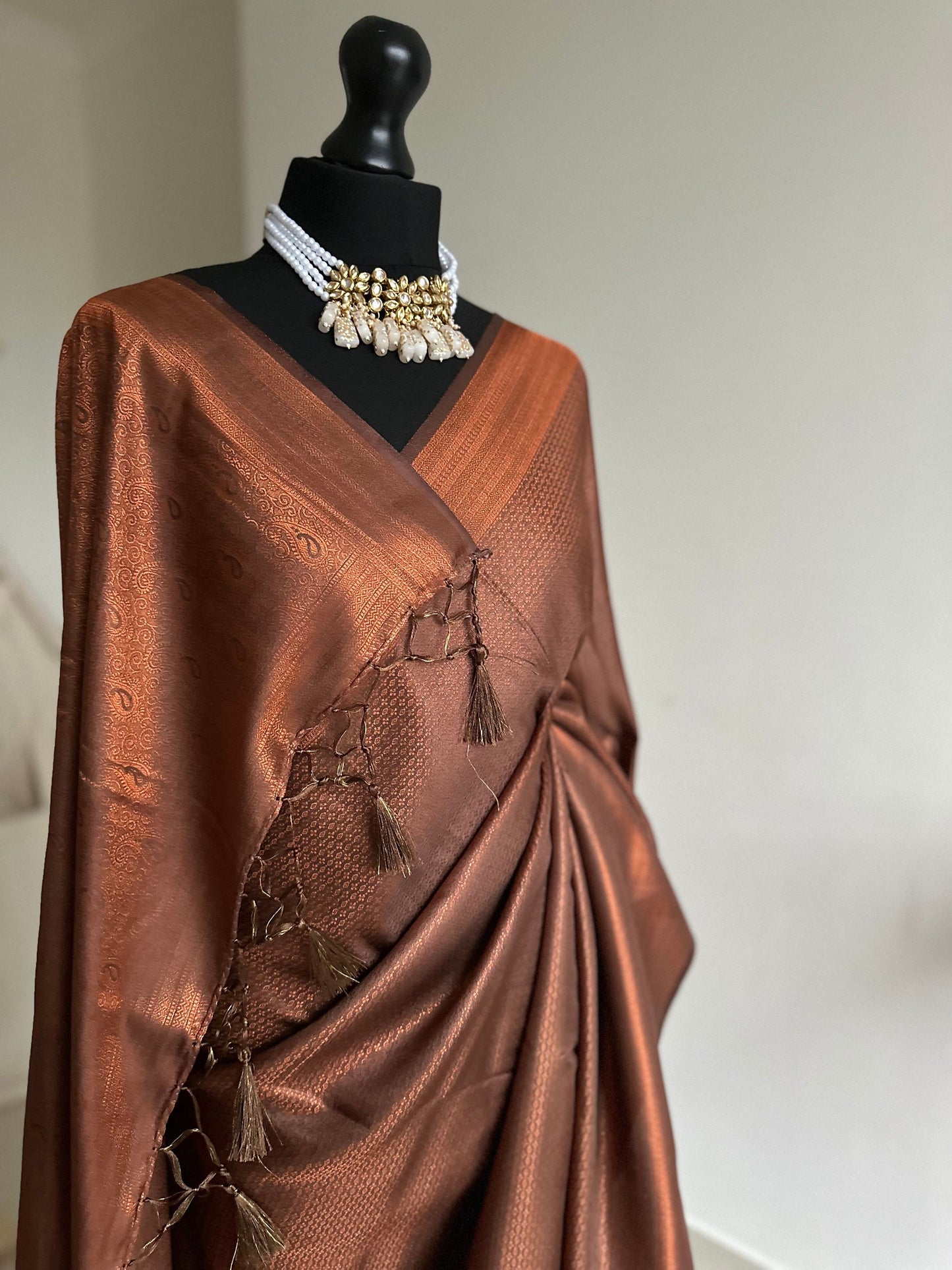 Chocolate brown and copper softy silk saree with subtle border and all over sheen. The perfect saree for parties and all traditional events.