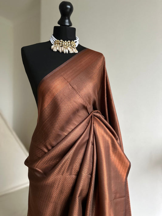 Chocolate brown and copper softy silk saree with subtle border and all over sheen. The perfect saree for parties and all traditional events.