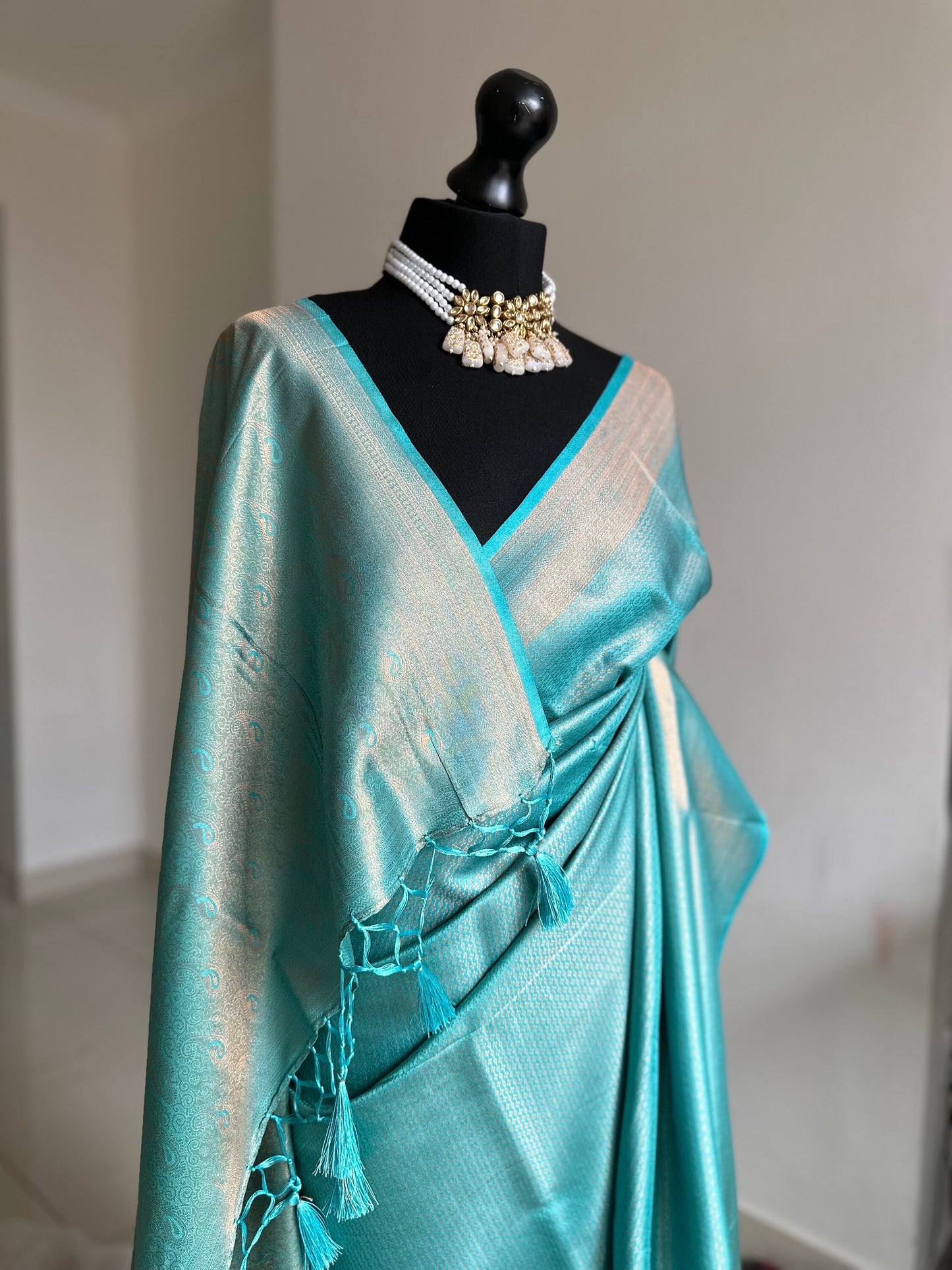 Light blue aqua soft silk saree with a copper border and all over sheen. The perfect saree for parties and all traditional events.