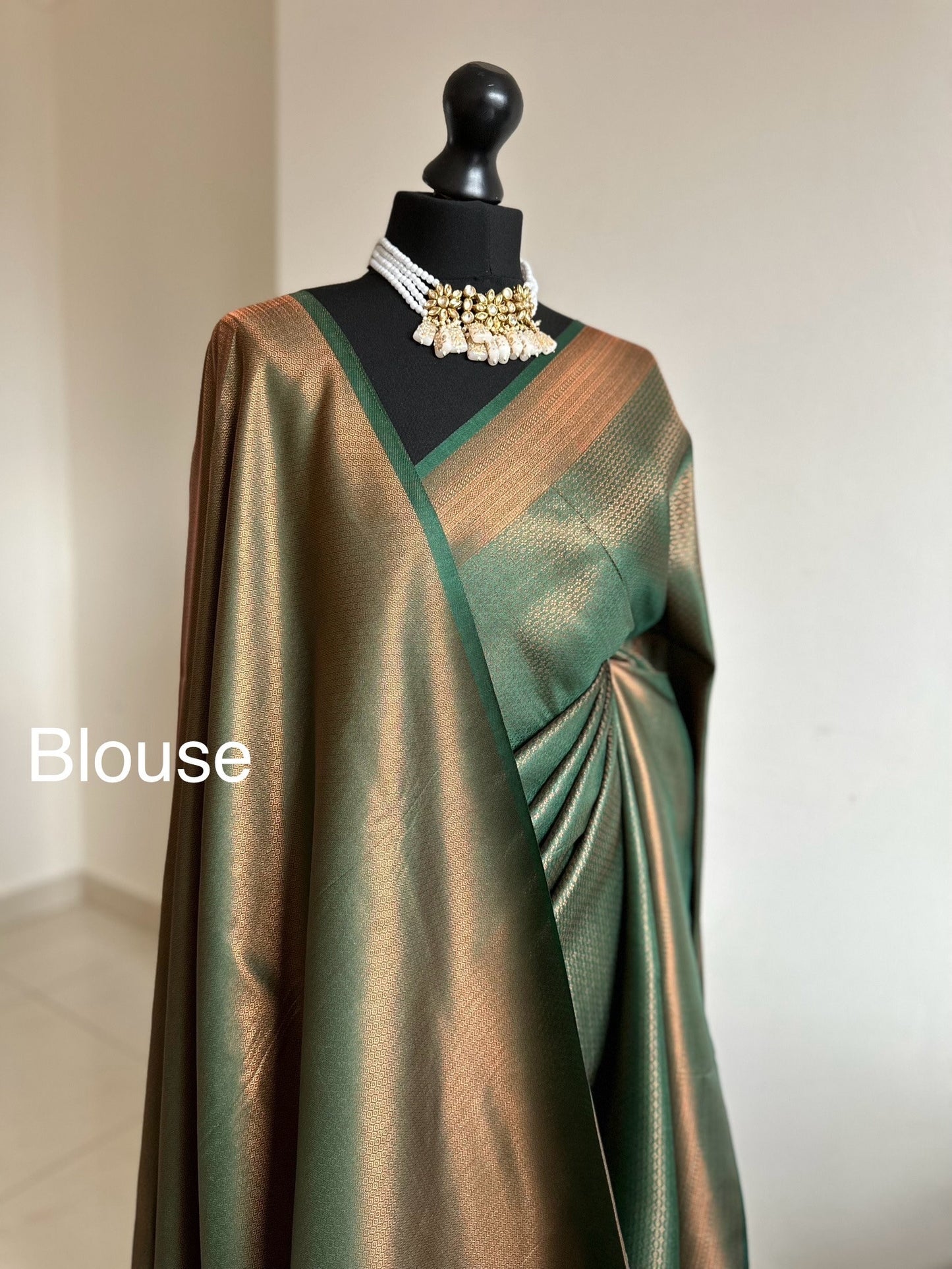 Bottle green silk saree with a copper border and all over sheen. The perfect saree for parties and all traditional events. Versatile saree